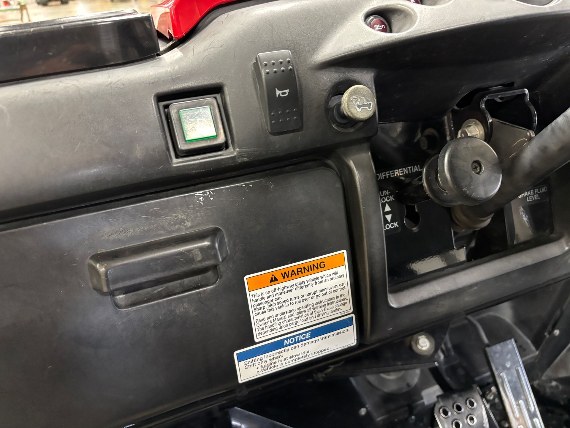 Dashboard with switches, ignition, and warning labels on a vehicle.