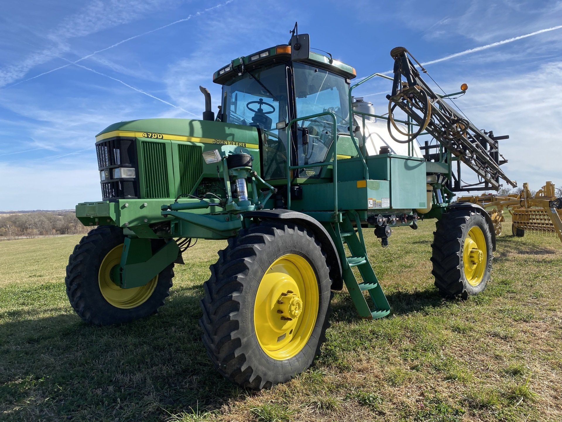 Green John Deere sprayer in a field.