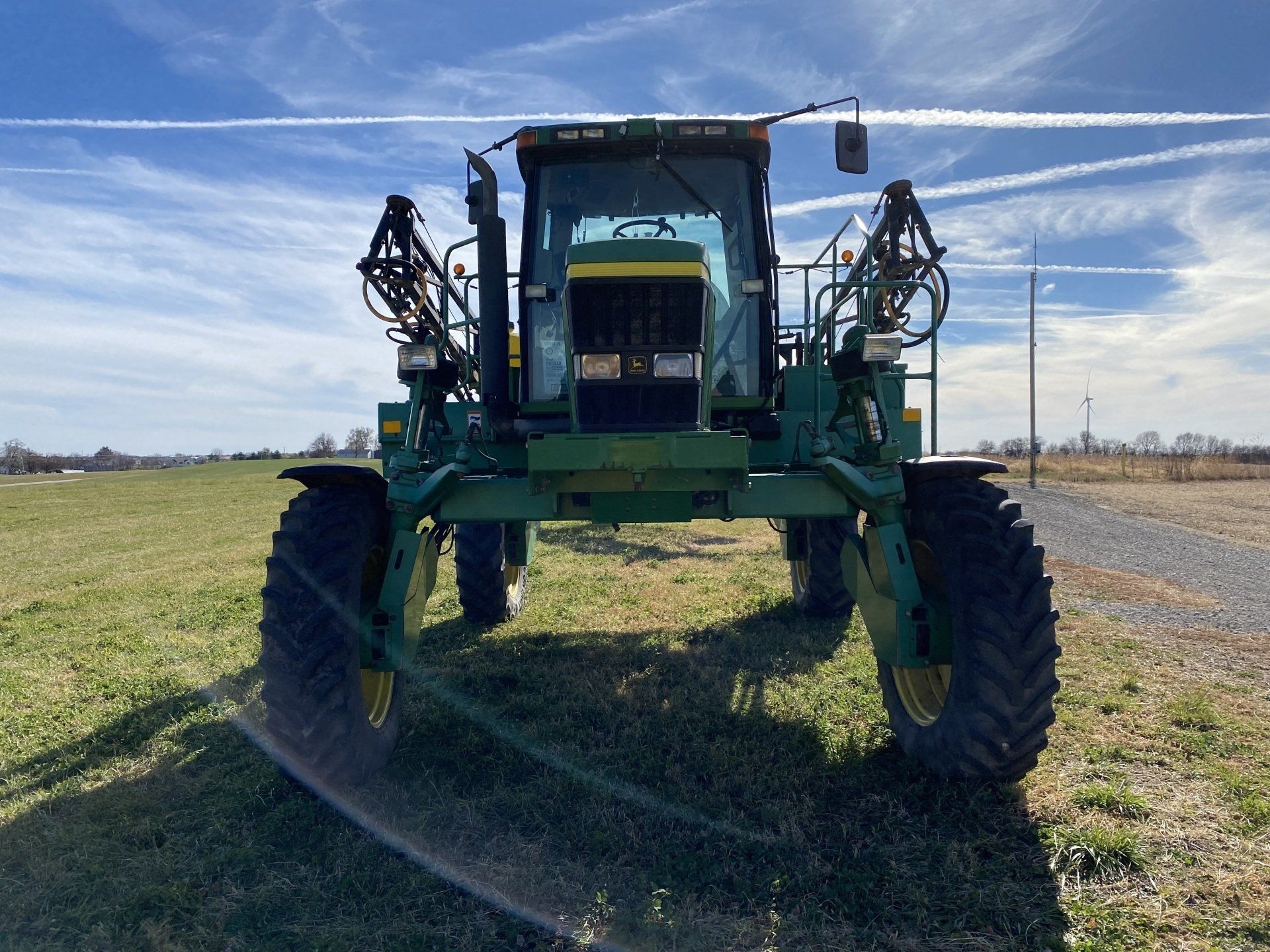 Green John Deere sprayer in a field.