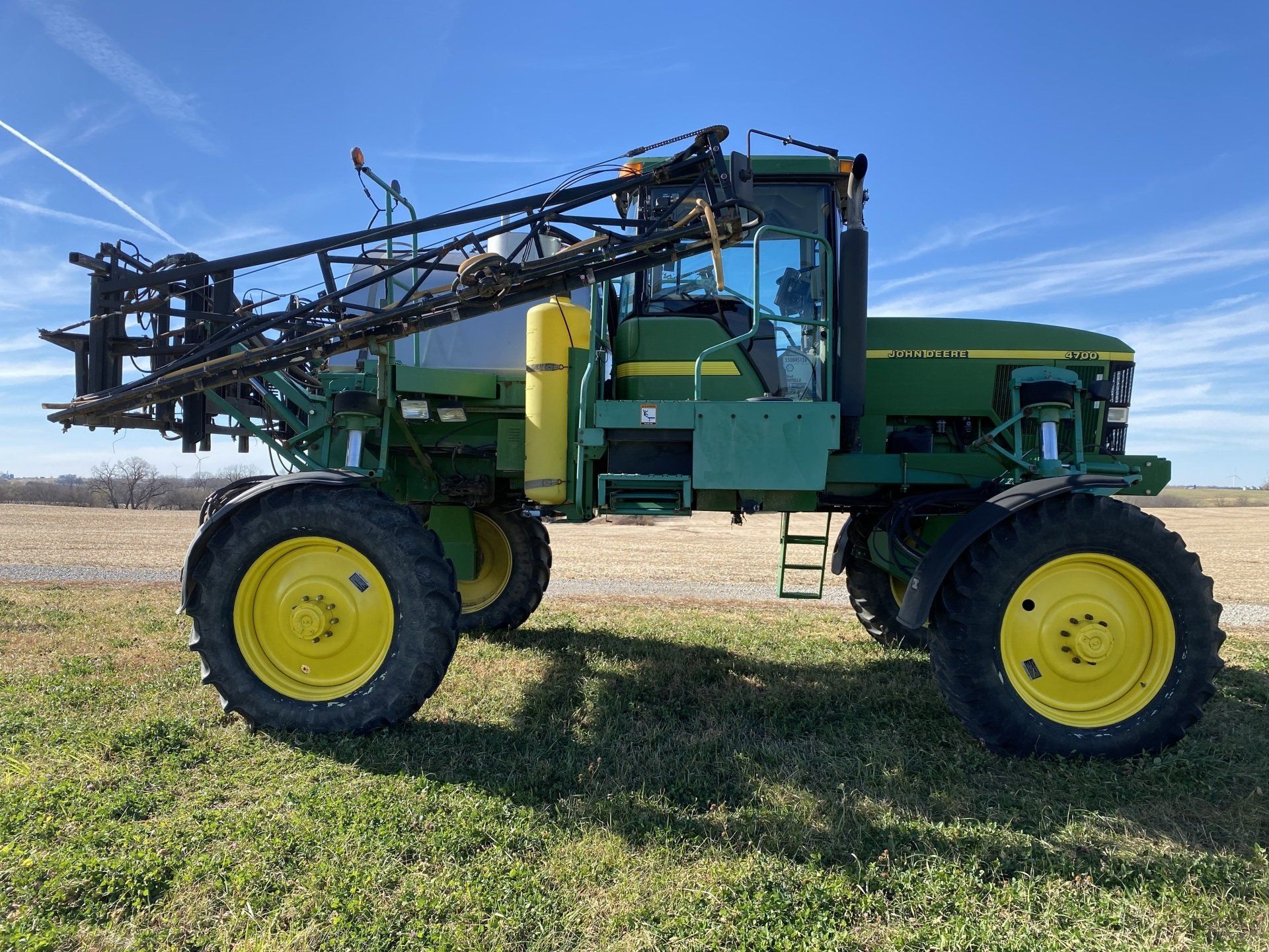 John Deere green agricultural sprayer in a field.