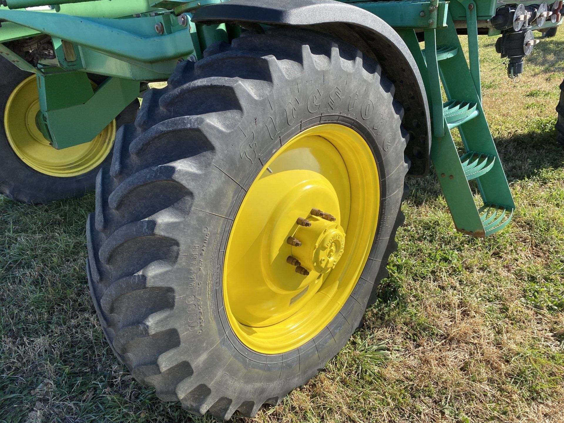 Close-up of a large yellow tractor wheel with black tread.