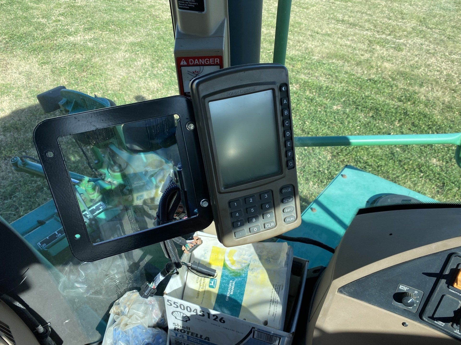 Interior view of a tractor cab with navigation screen and control panel.