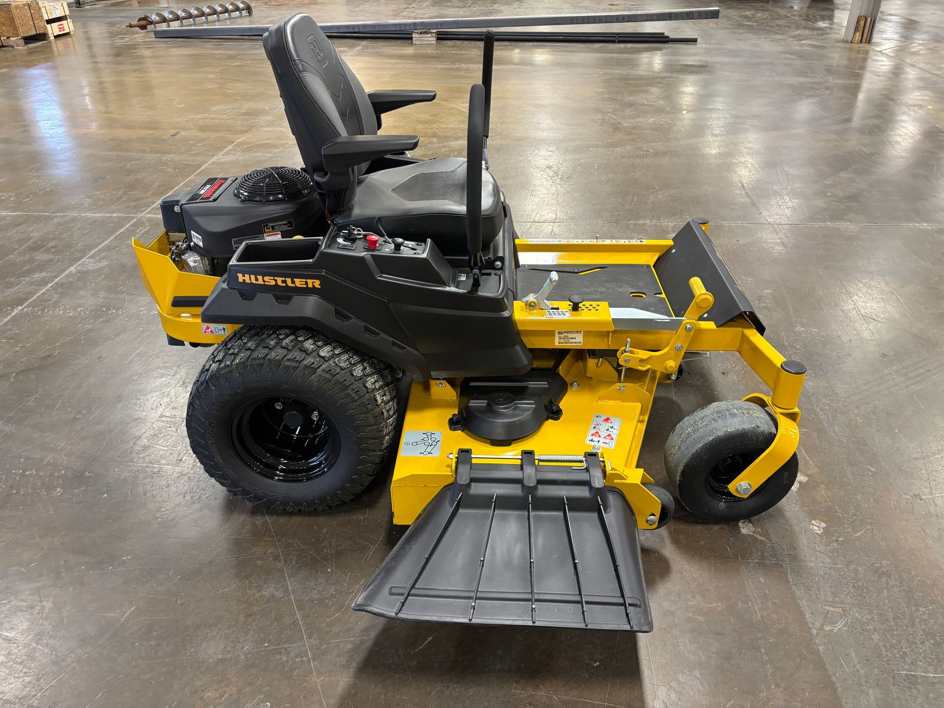 Yellow and black zero-turn lawn mower on a concrete floor.