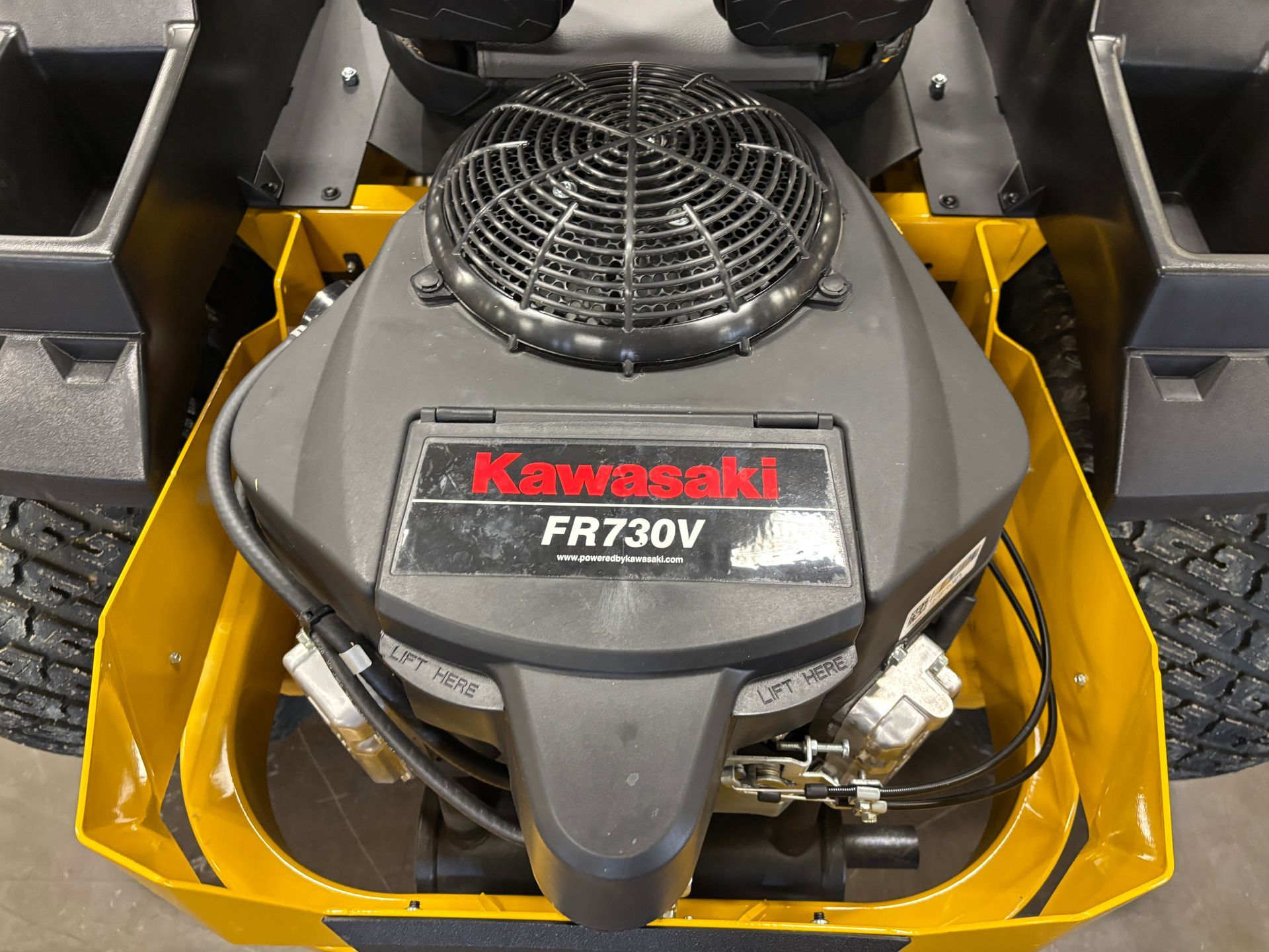 Close-up of a Kawasaki FR730V engine on a yellow zero-turn mower.