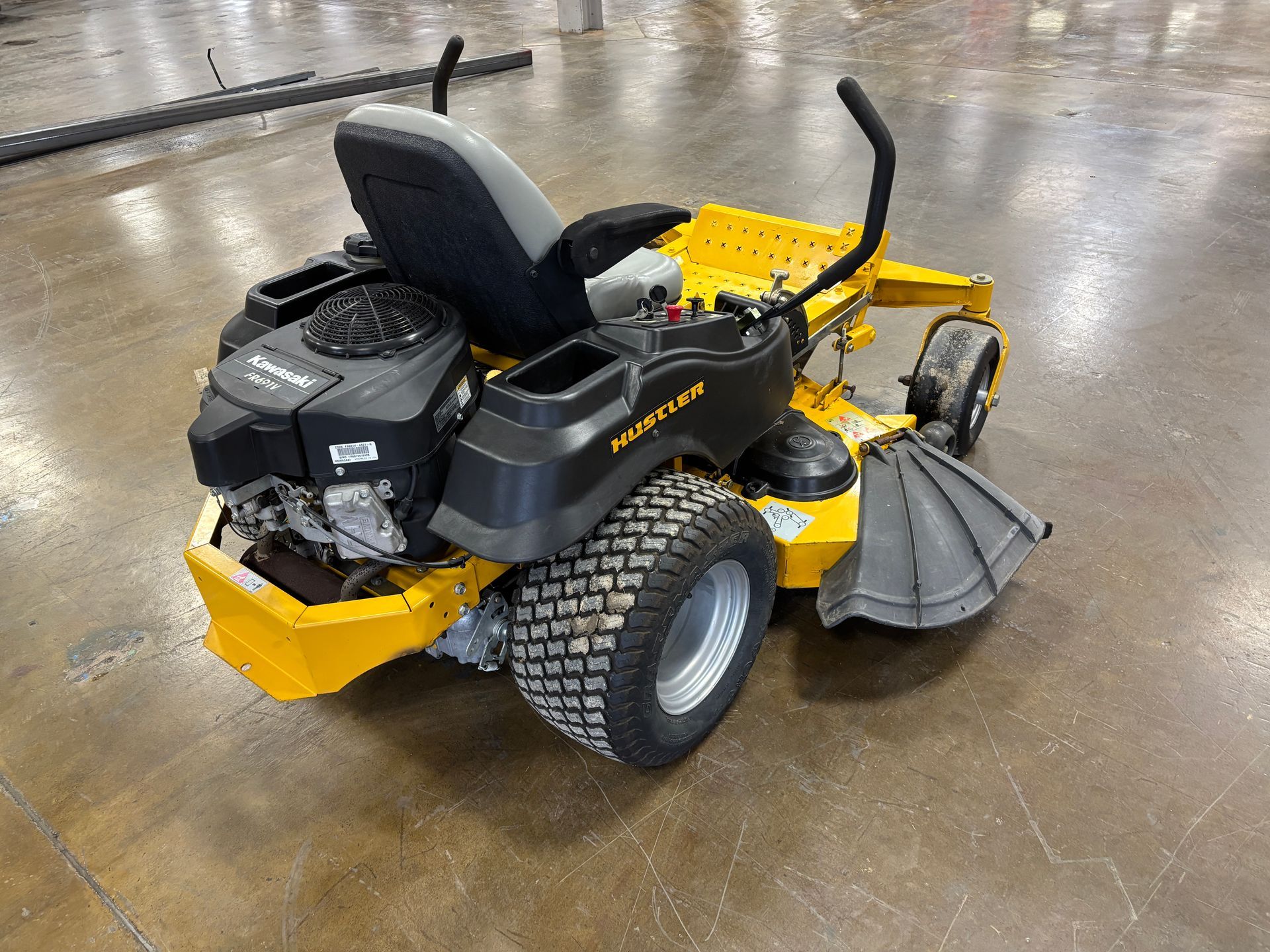 Yellow and black commercial zero-turn mower on a concrete floor.