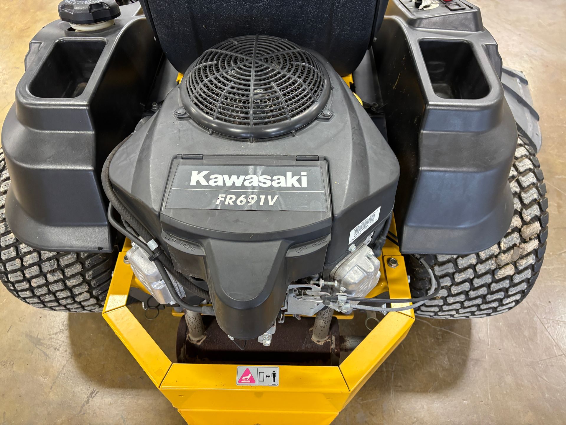 A zero-turn lawnmower with a Kawasaki FR691V engine and black fan.