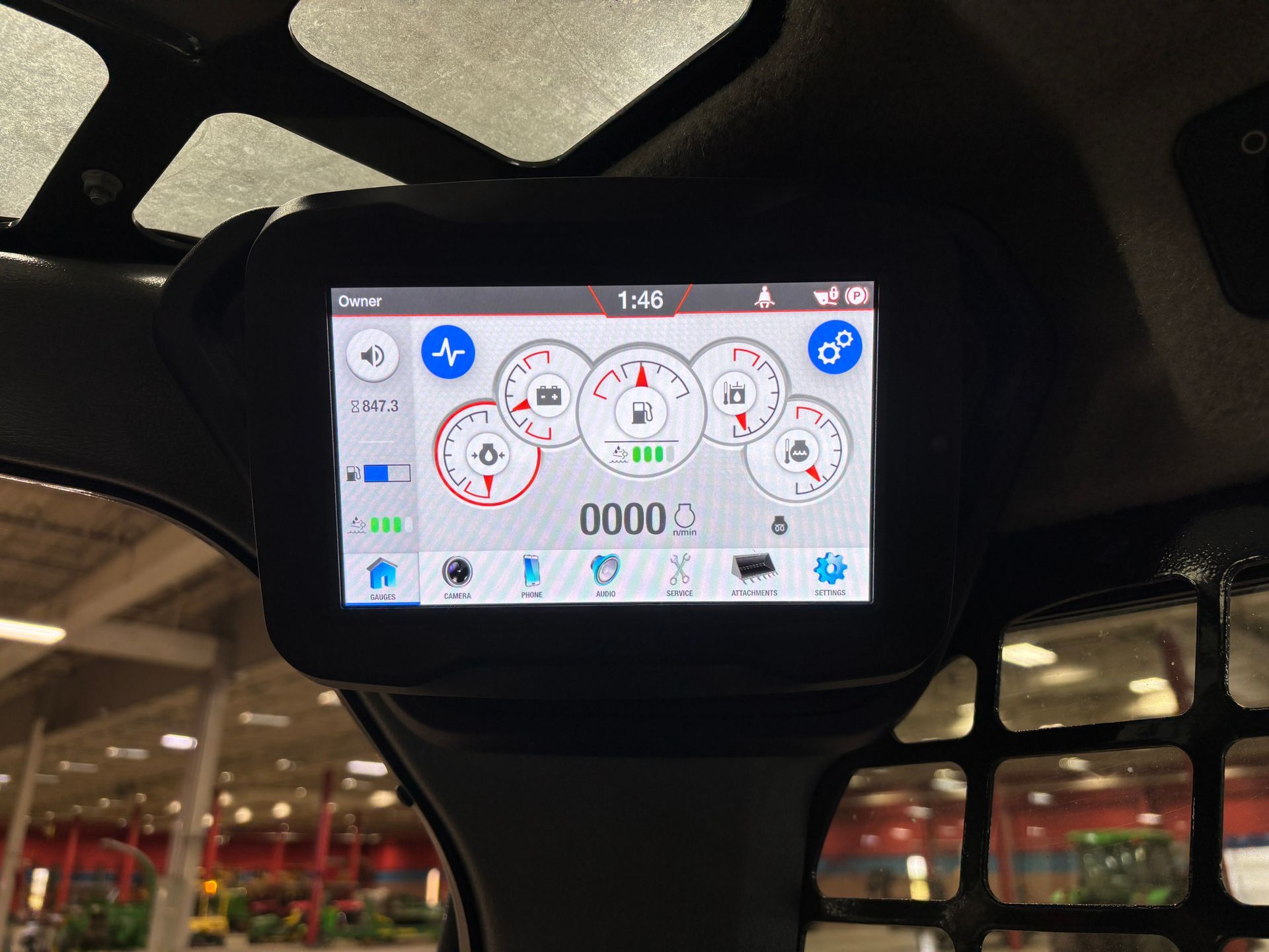Dashboard screen displaying gauges and machine information in a compact track loader.
