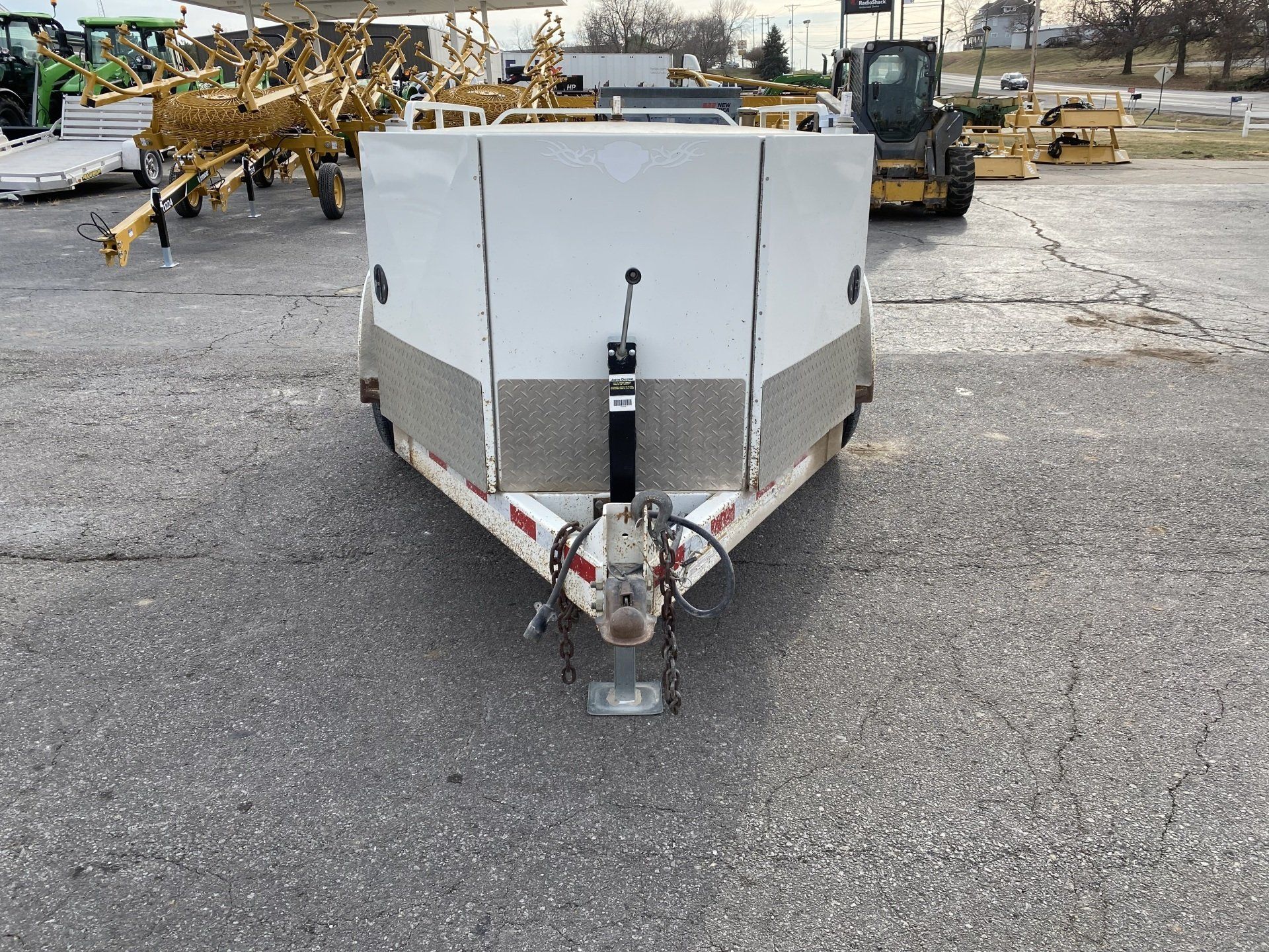 White fuel trailer with a silver front panel, parked on asphalt, front shot.