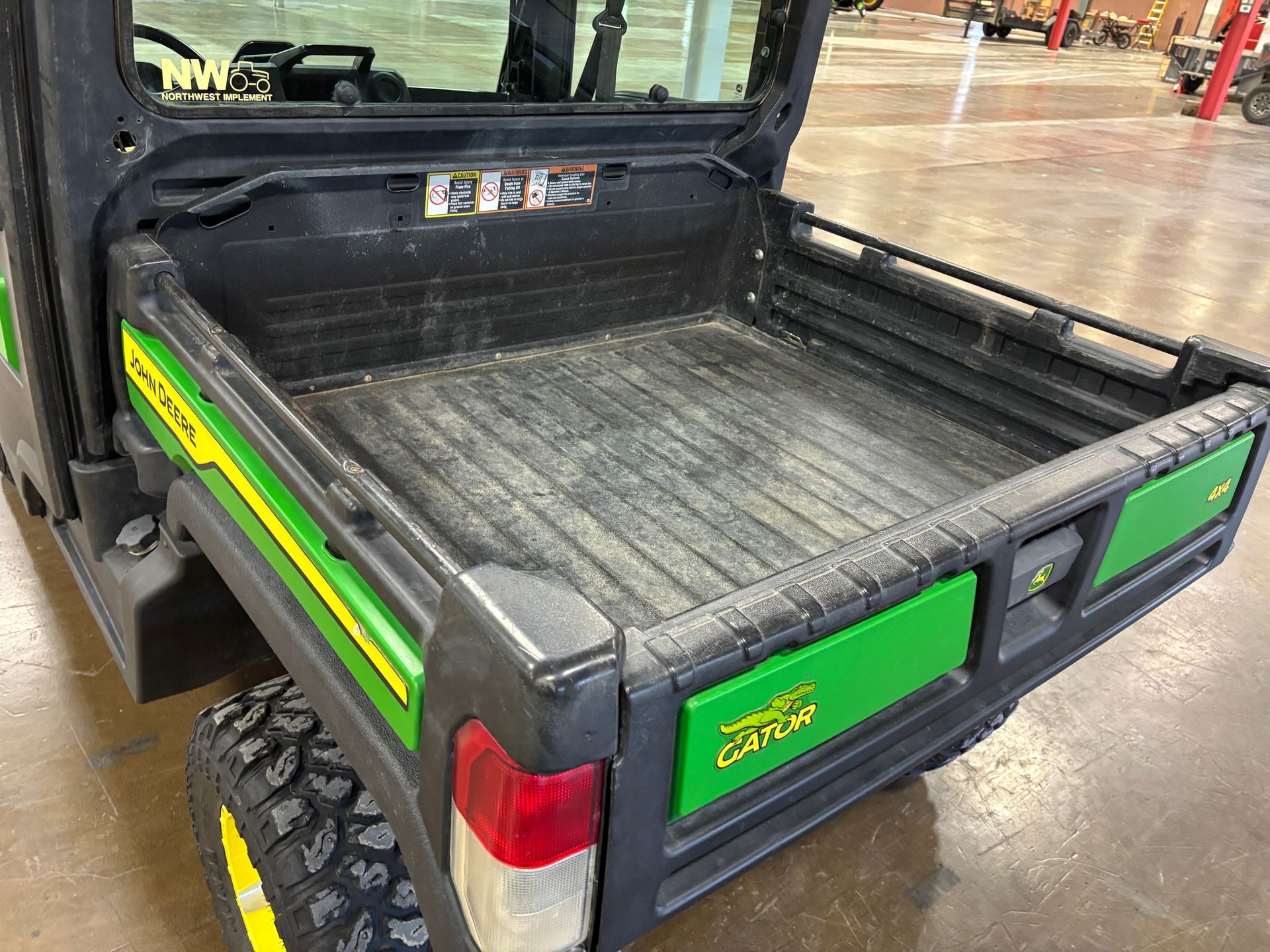 John Deere Gator utility vehicle with a black and green bed.