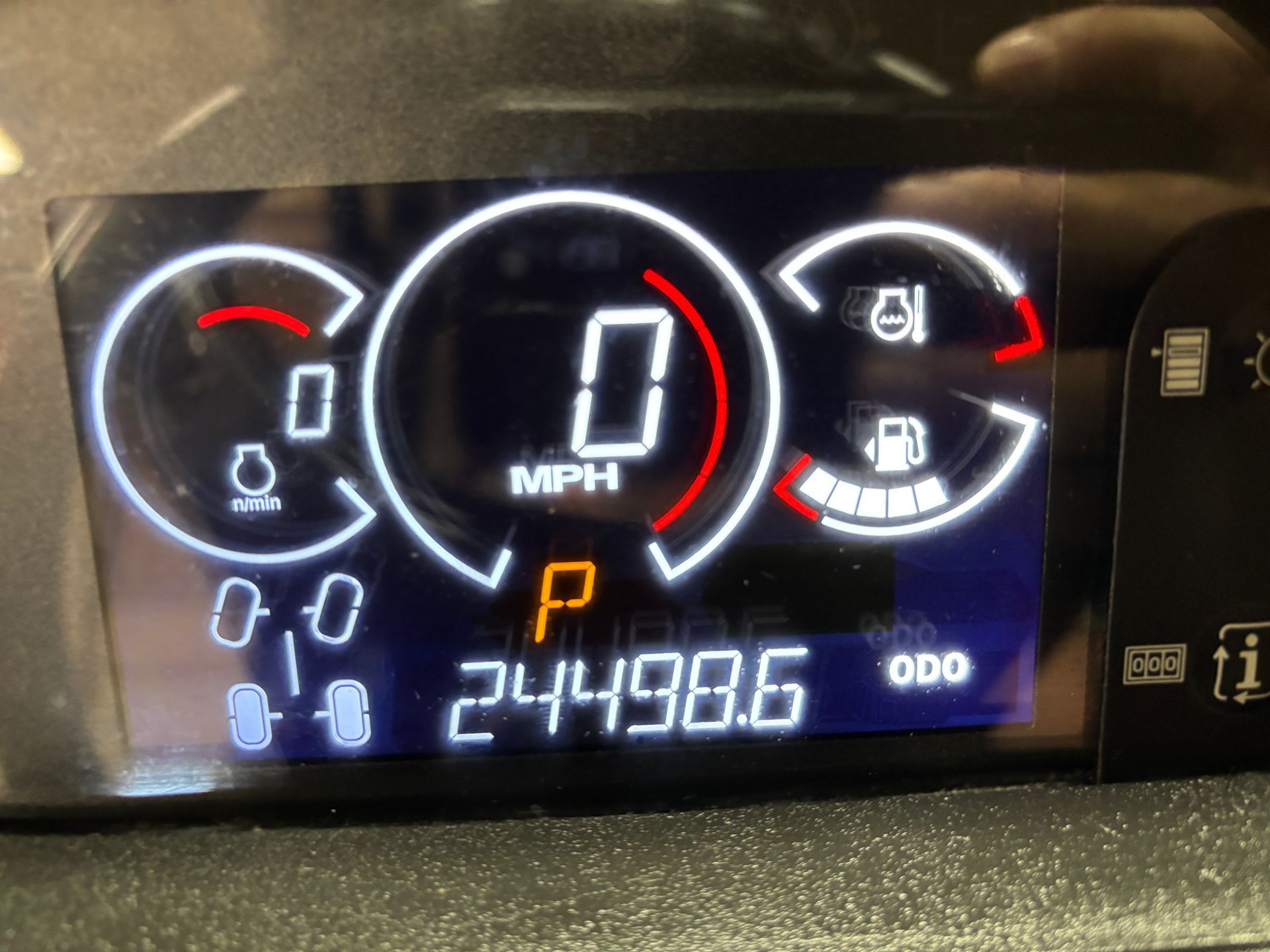 Car dashboard displays: Speed at 0 mph, fuel gauge, parking gear engaged, and 24498.6 miles.