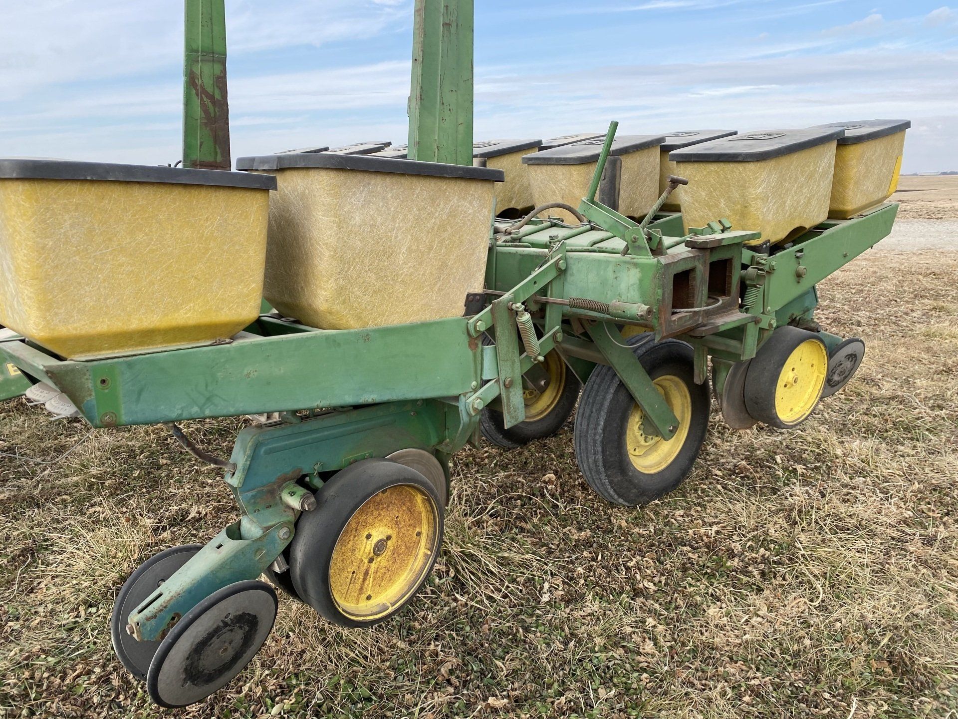 Green and yellow John Deere planter in a field.
