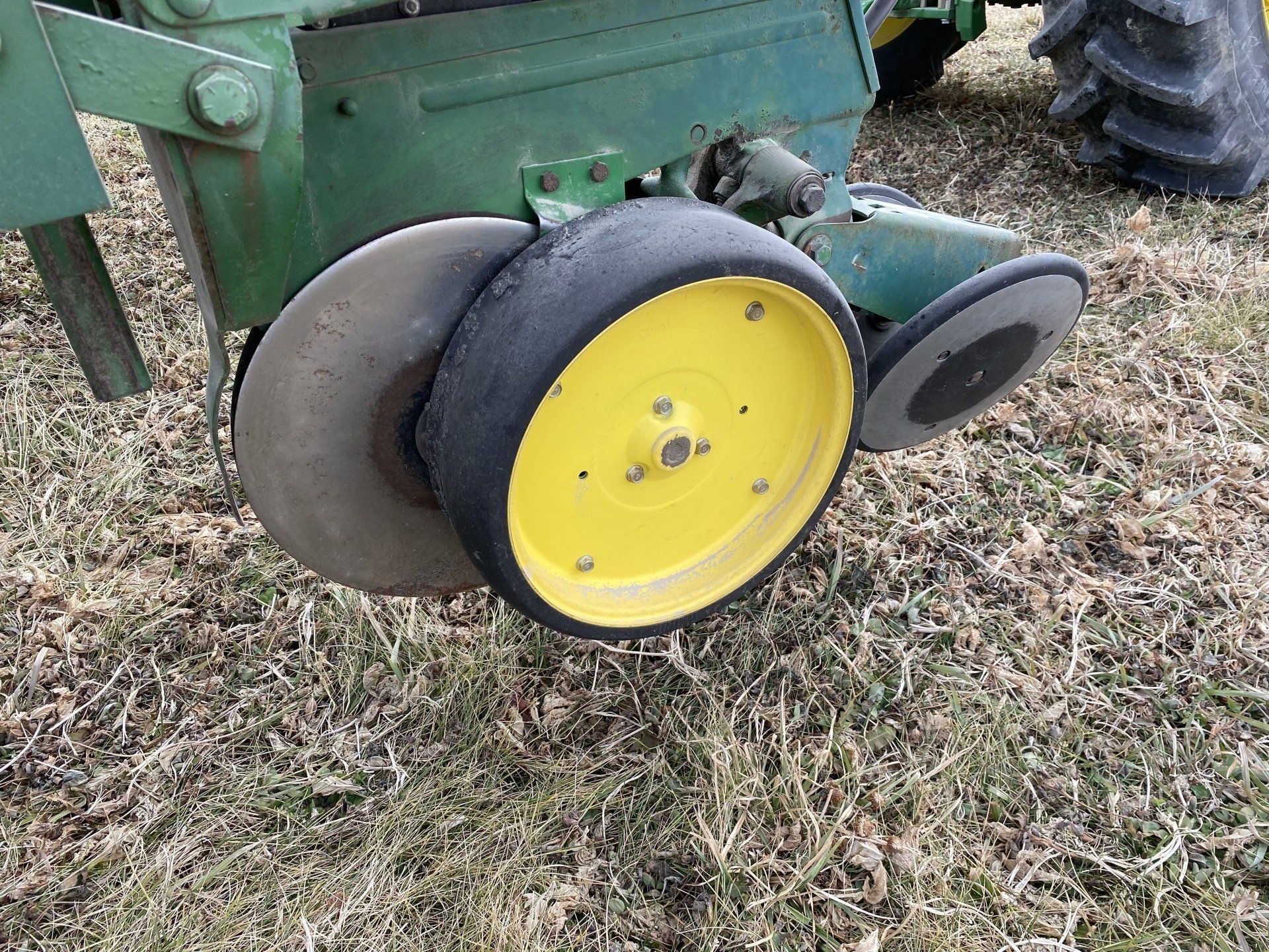 John Deere tractor with a planter in a field.