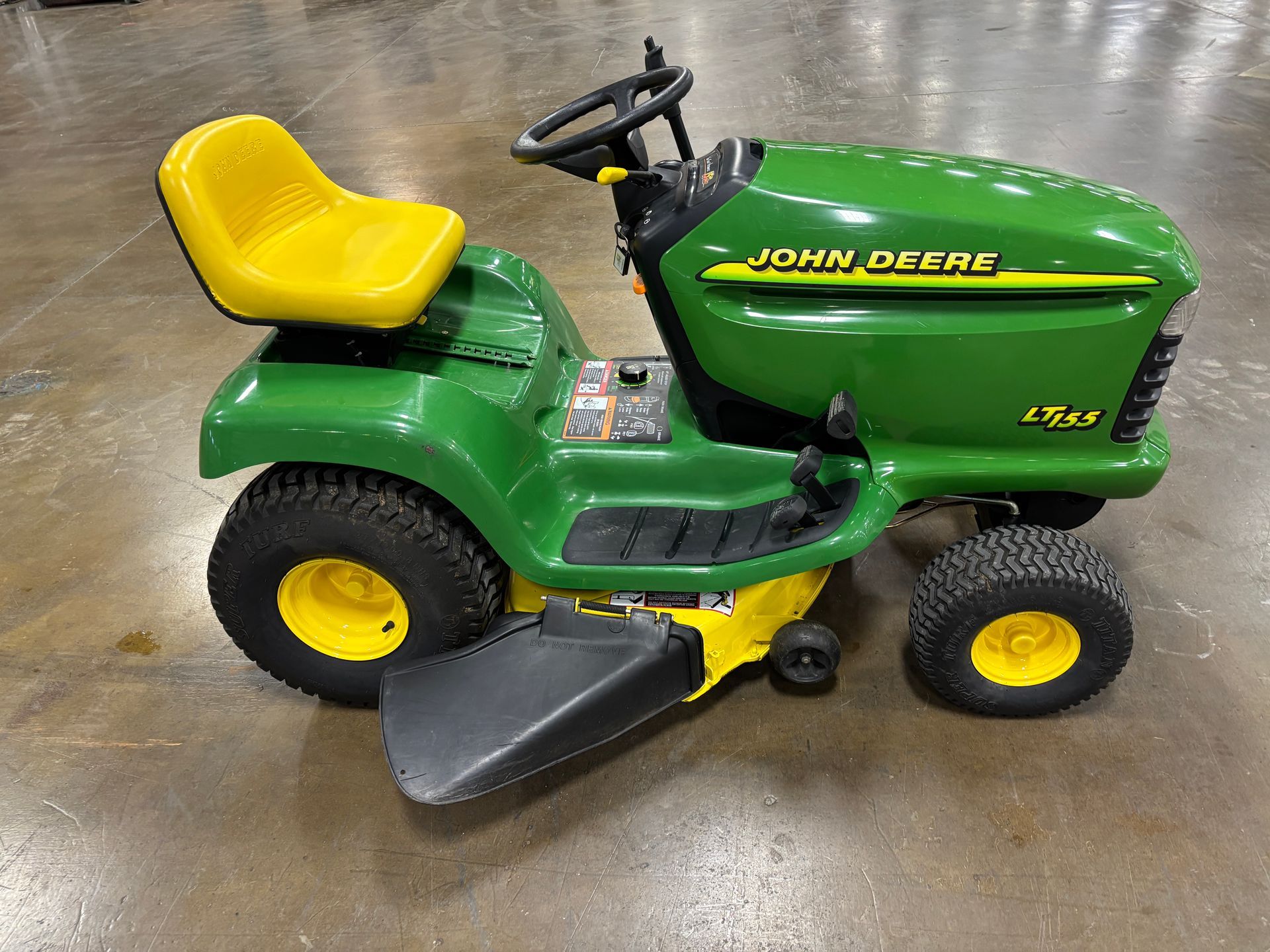 Green and yellow John Deere LT160 riding lawn mower.