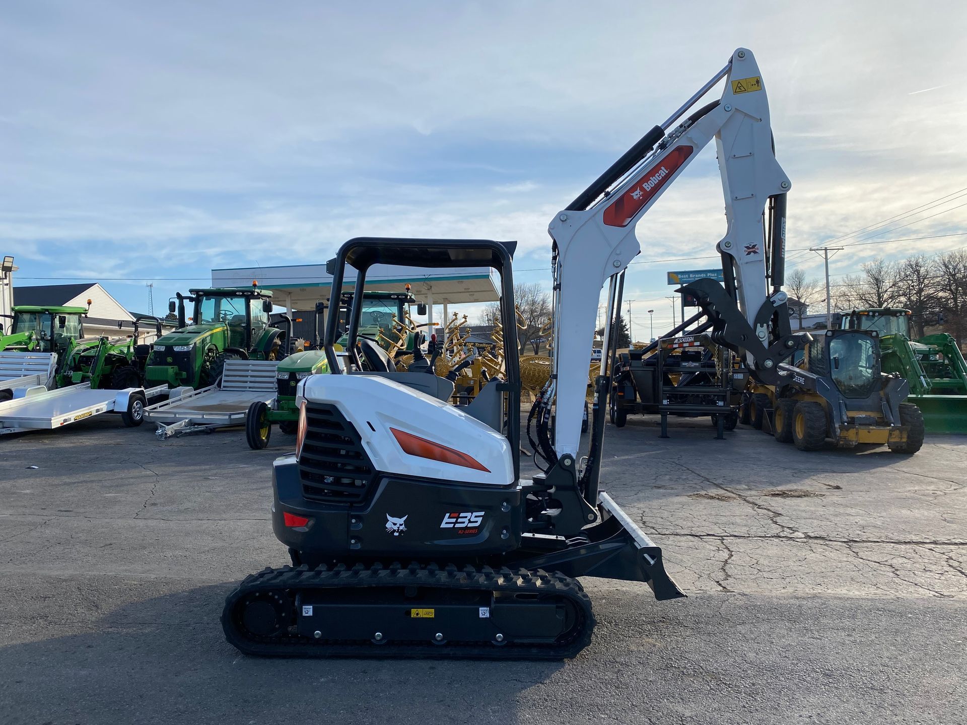 White Bobcat E27 mini excavator parked outside a machinery dealership.