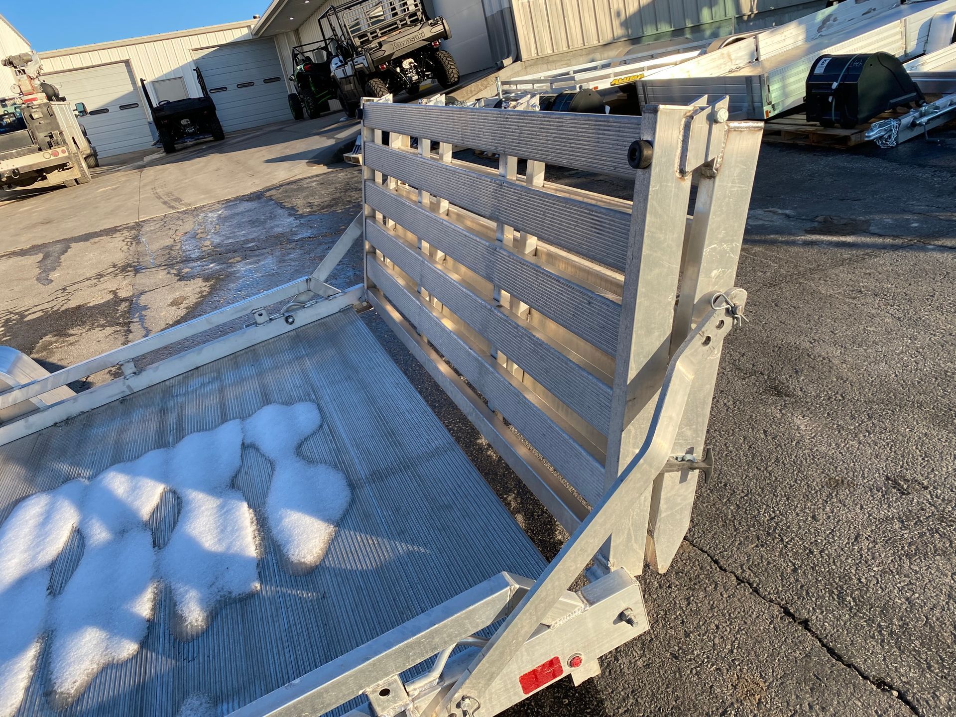 Inside of a snow-covered trailer with aluminum side railings, parked outdoors.