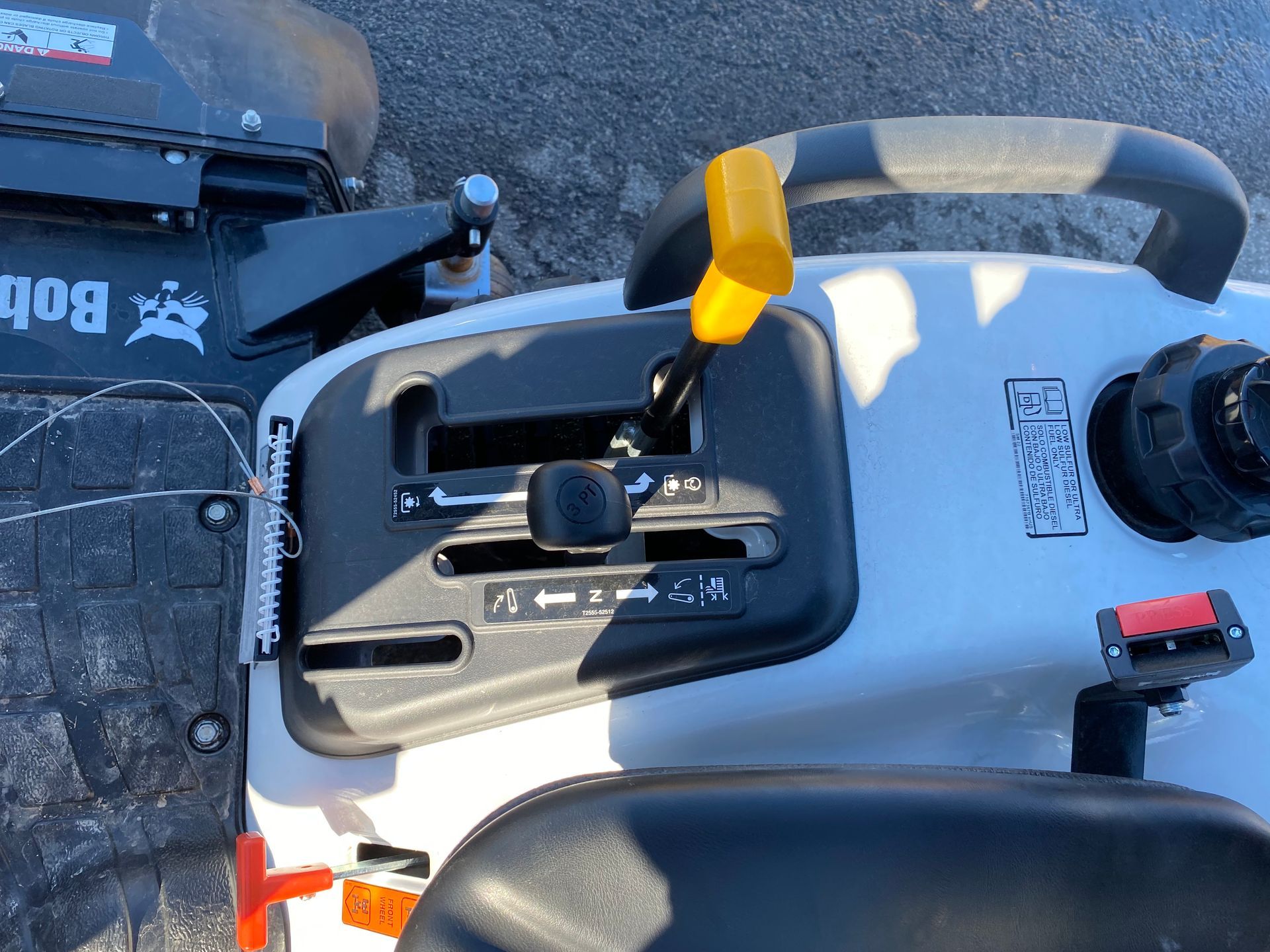 Dashboard controls of a Bobcat tractor, including speed and blade height adjustments.
