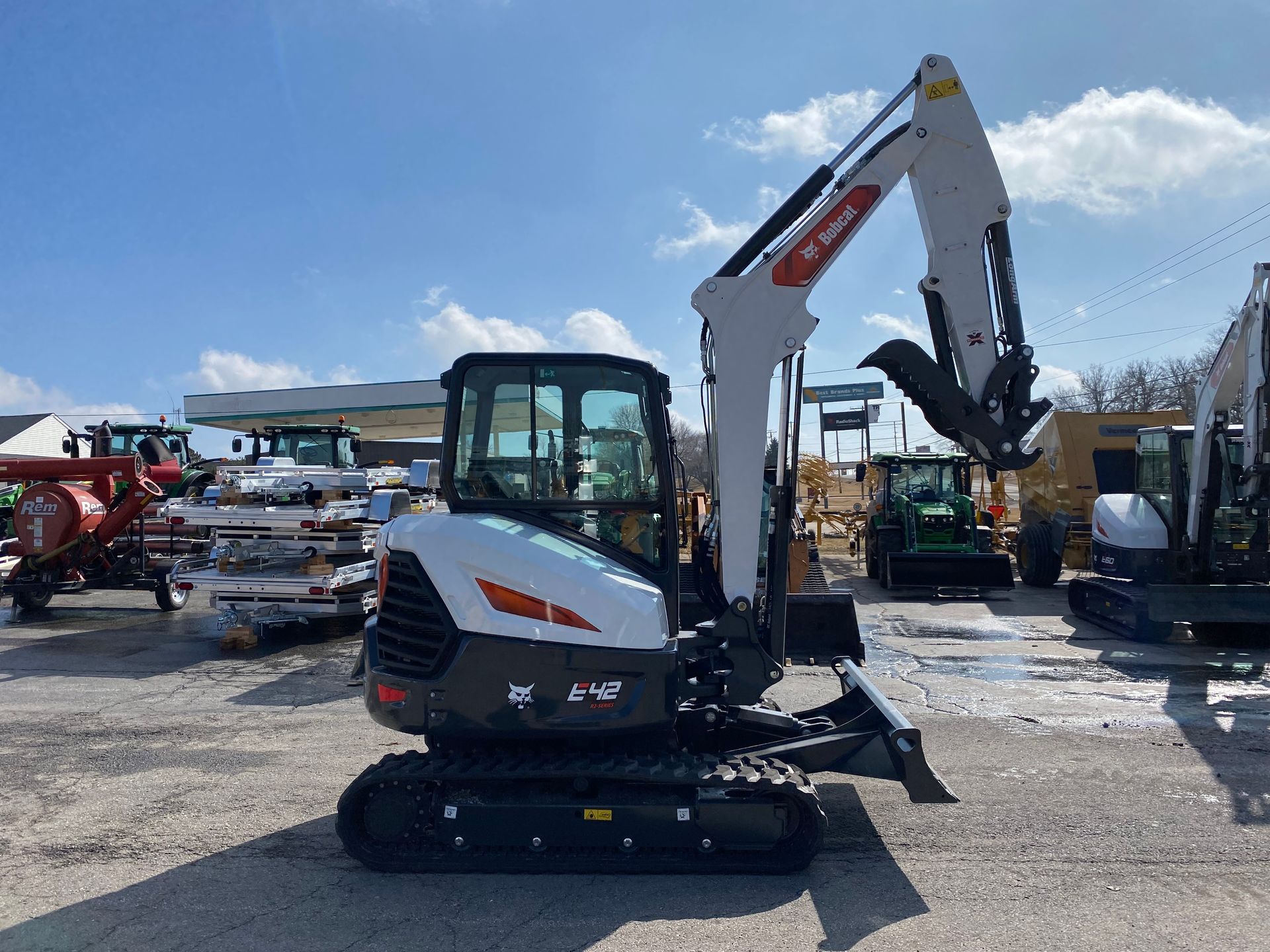 White and black Bobcat excavator parked outdoors.