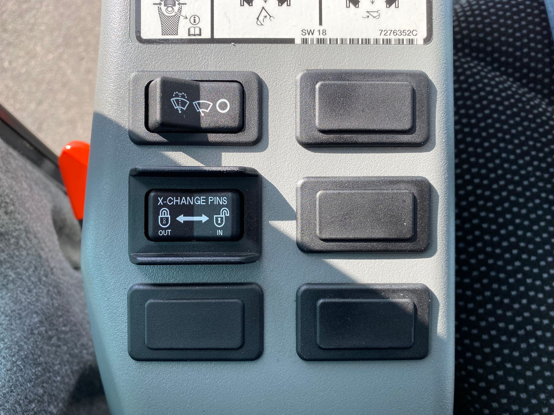 Control panel with buttons. One button has a windshield wiper symbol, another has a fuel gauge and arrow symbol.