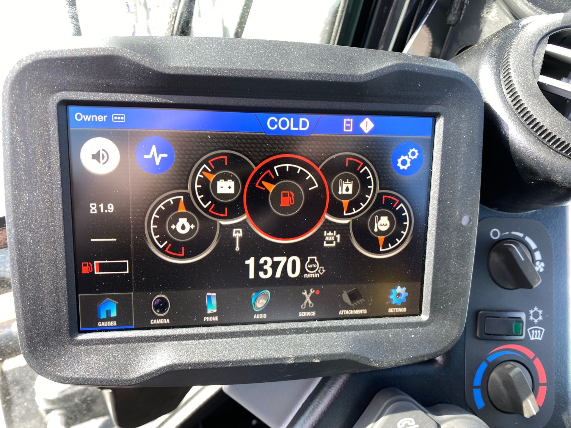 Dashboard display showing gauges and controls; screen reads 