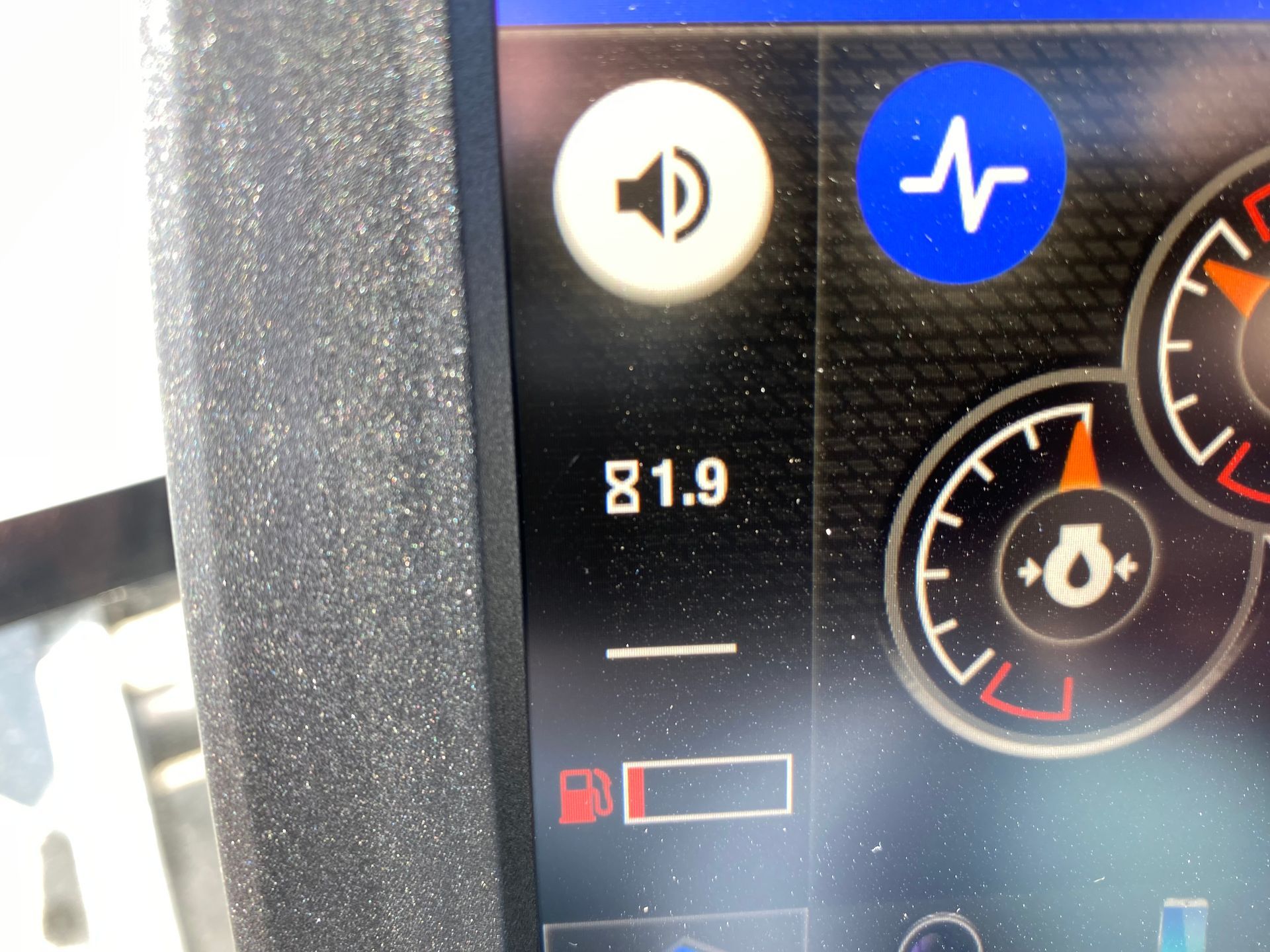 Vehicle dashboard display showing speaker icon, heartbeat icon, 