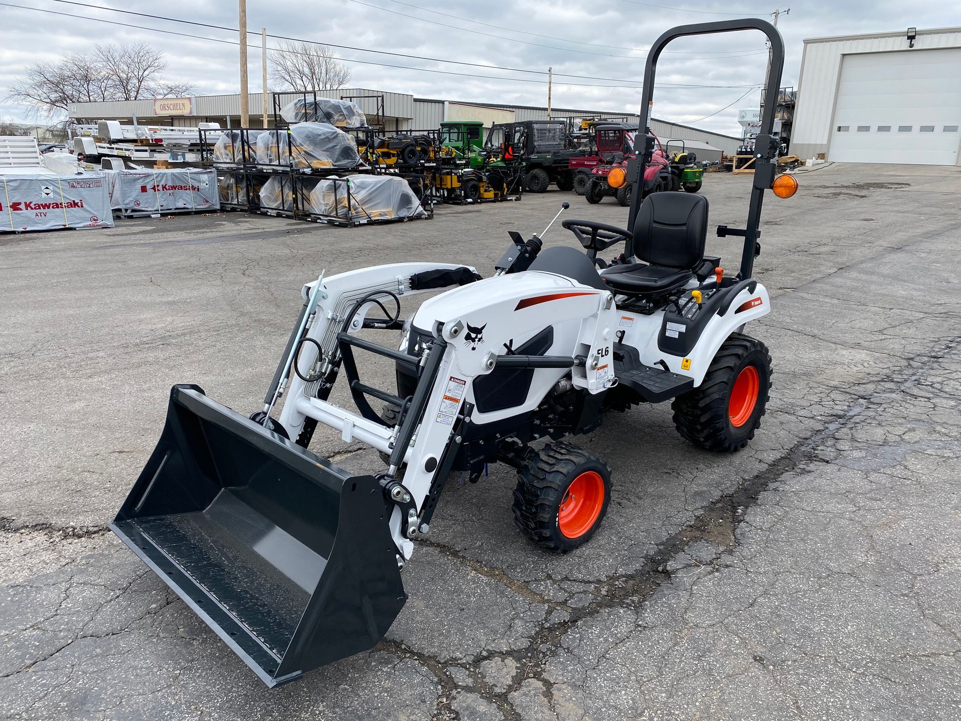 White Bobcat tractor with a front loader and orange wheels.
