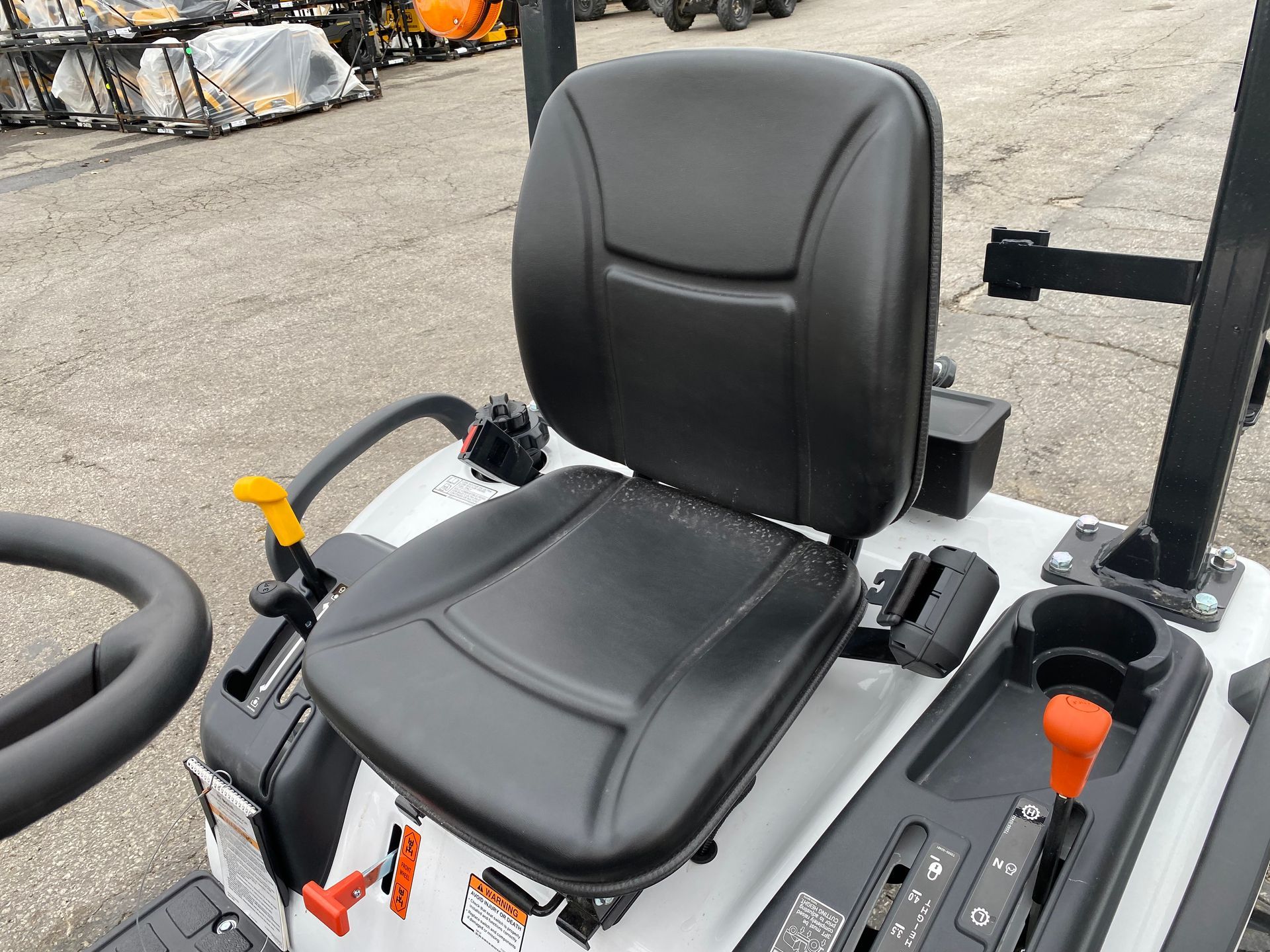 Black tractor seat with controls and cup holder.