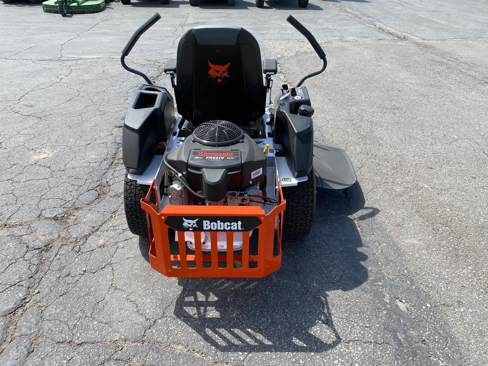 Bobcat zero-turn lawn mower, orange and gray, on asphalt.