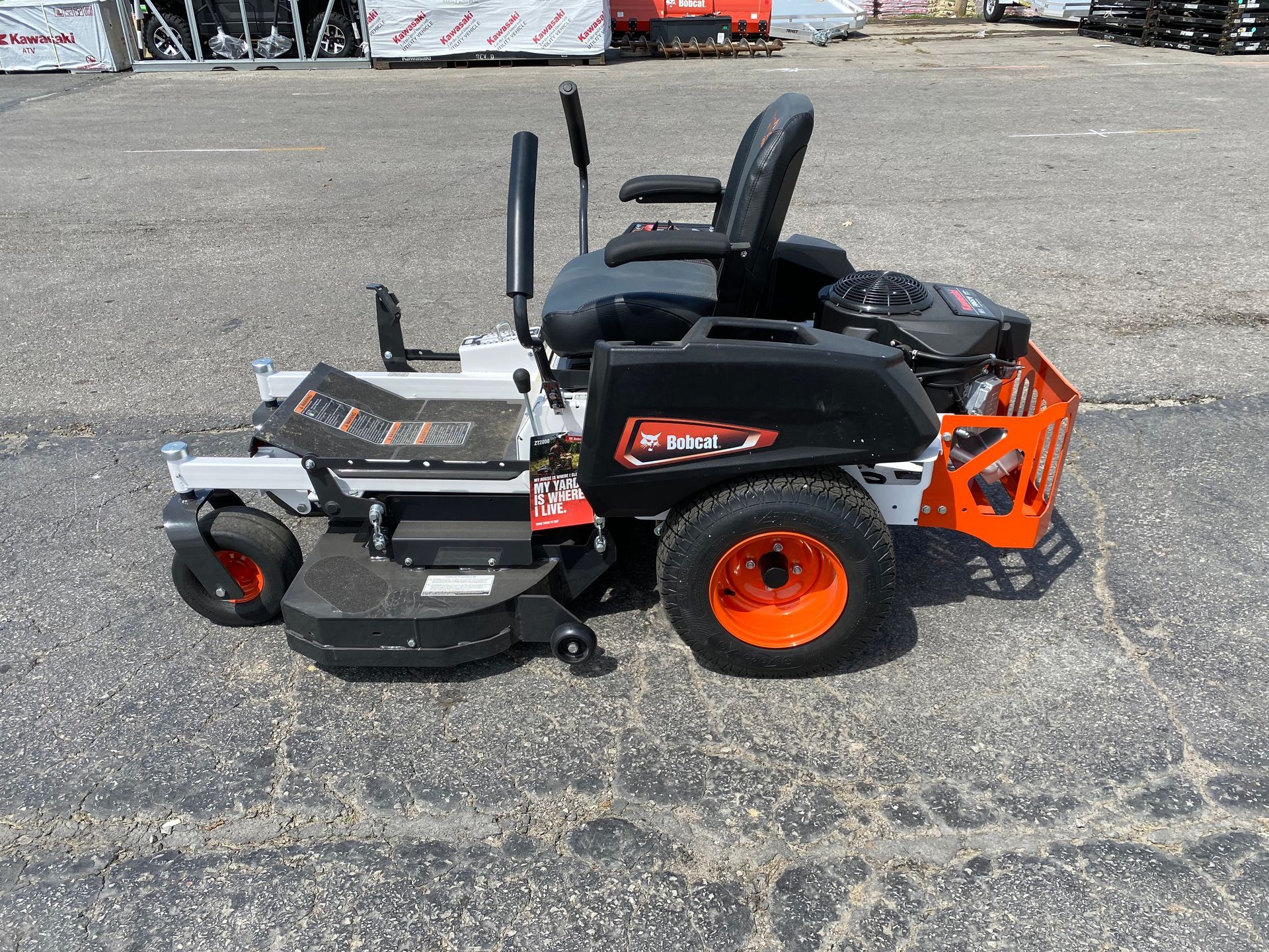 Black and orange zero-turn lawnmower on pavement.