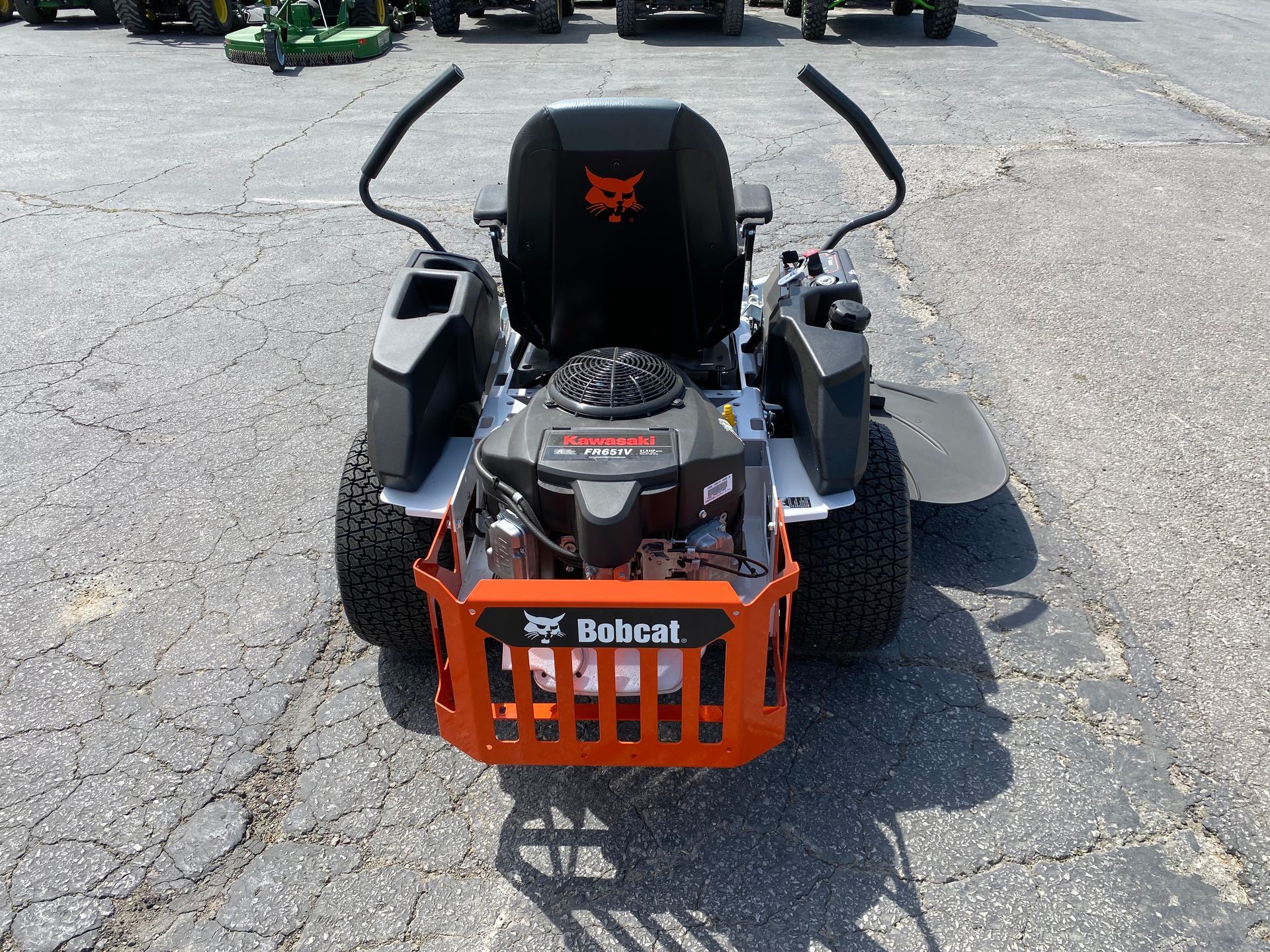 Bobcat zero-turn lawn mower, orange and black, parked on pavement.