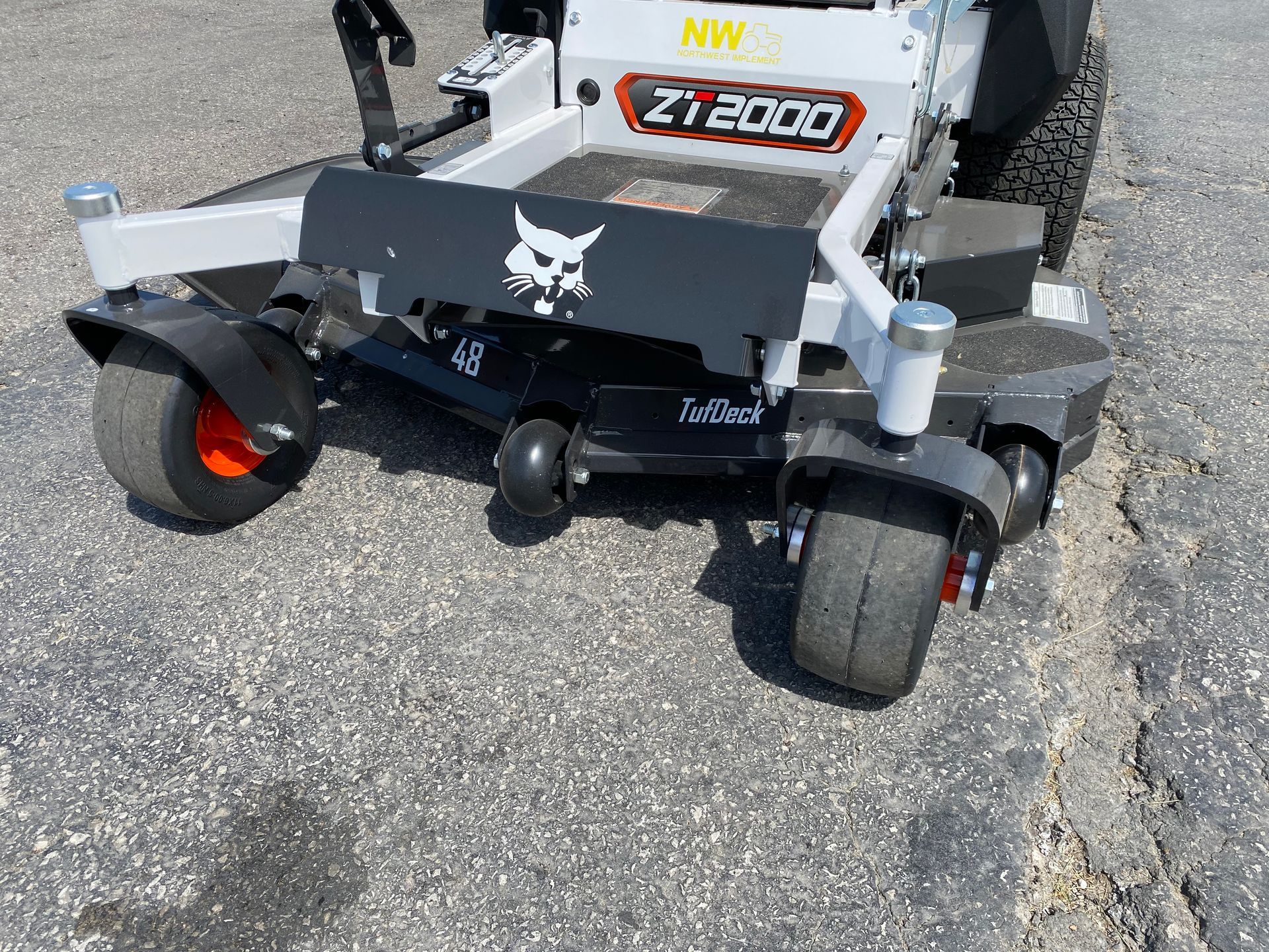 Bobcat ZT2000 zero-turn mower, black and white, on pavement. Front view showing wheels and cutting deck.