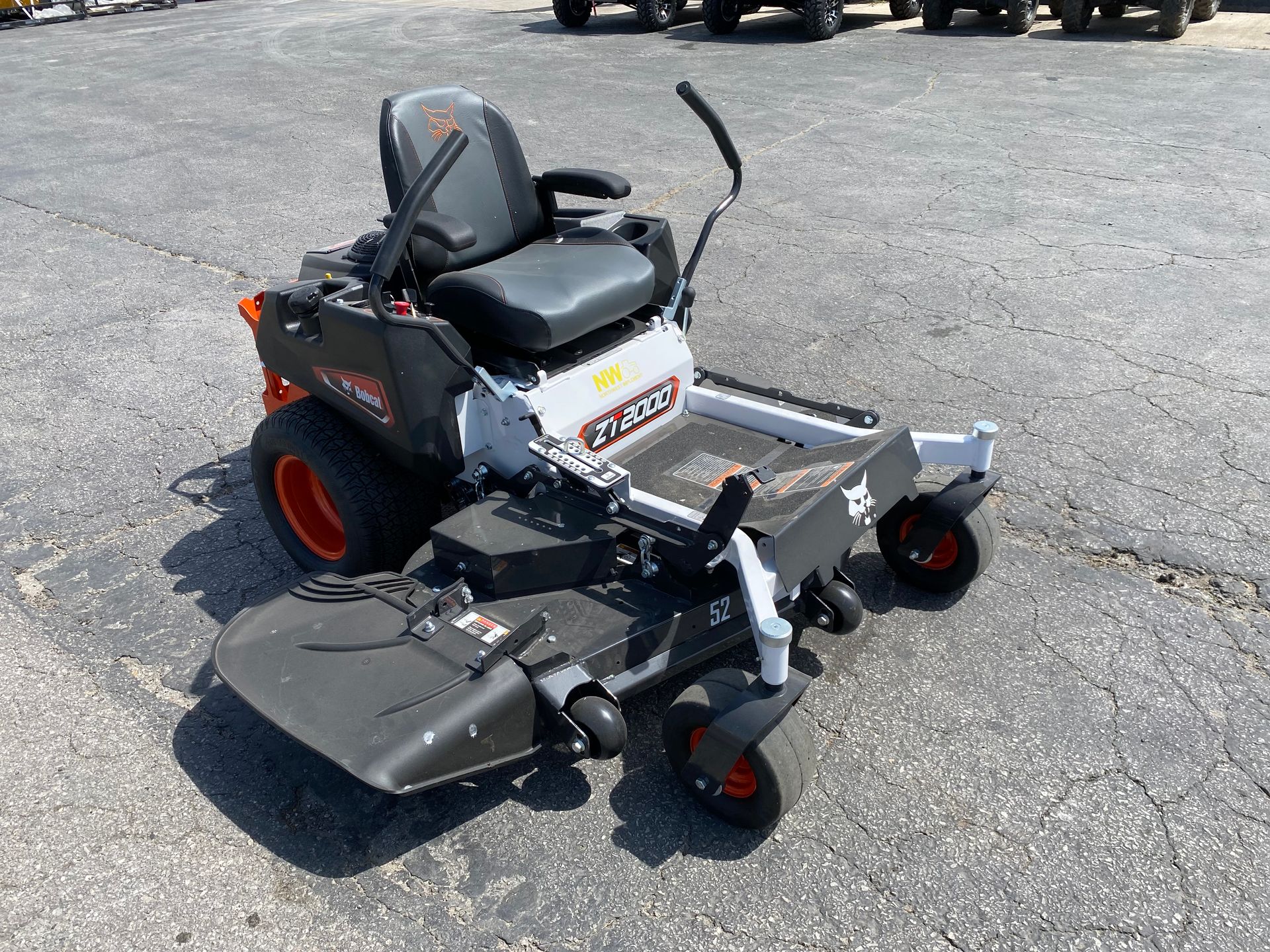 Orange and black Bobcat zero-turn lawn mower on a paved surface.