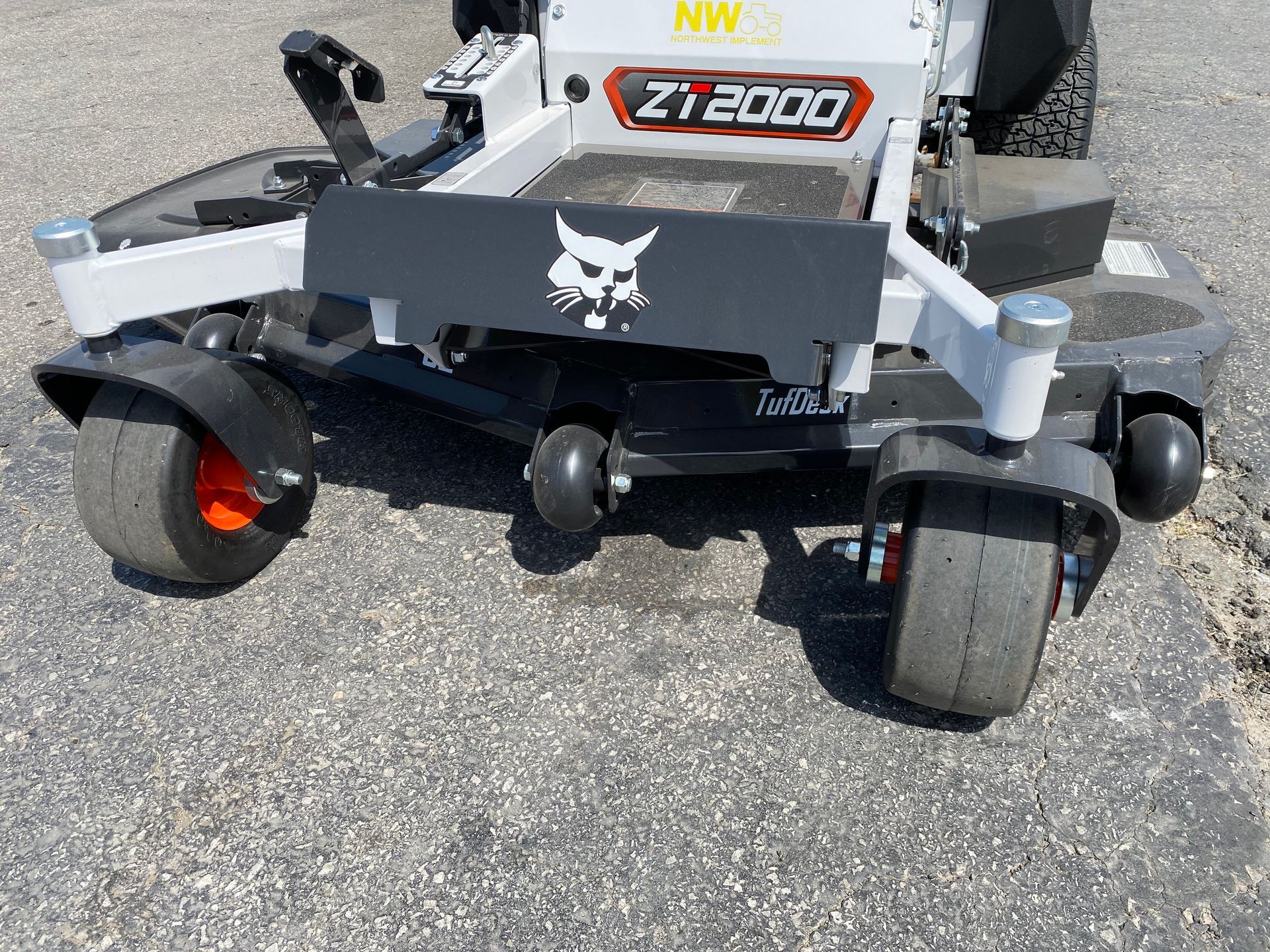 Bobcat ZT2000 zero-turn mower, black and white, orange wheels, on pavement.
