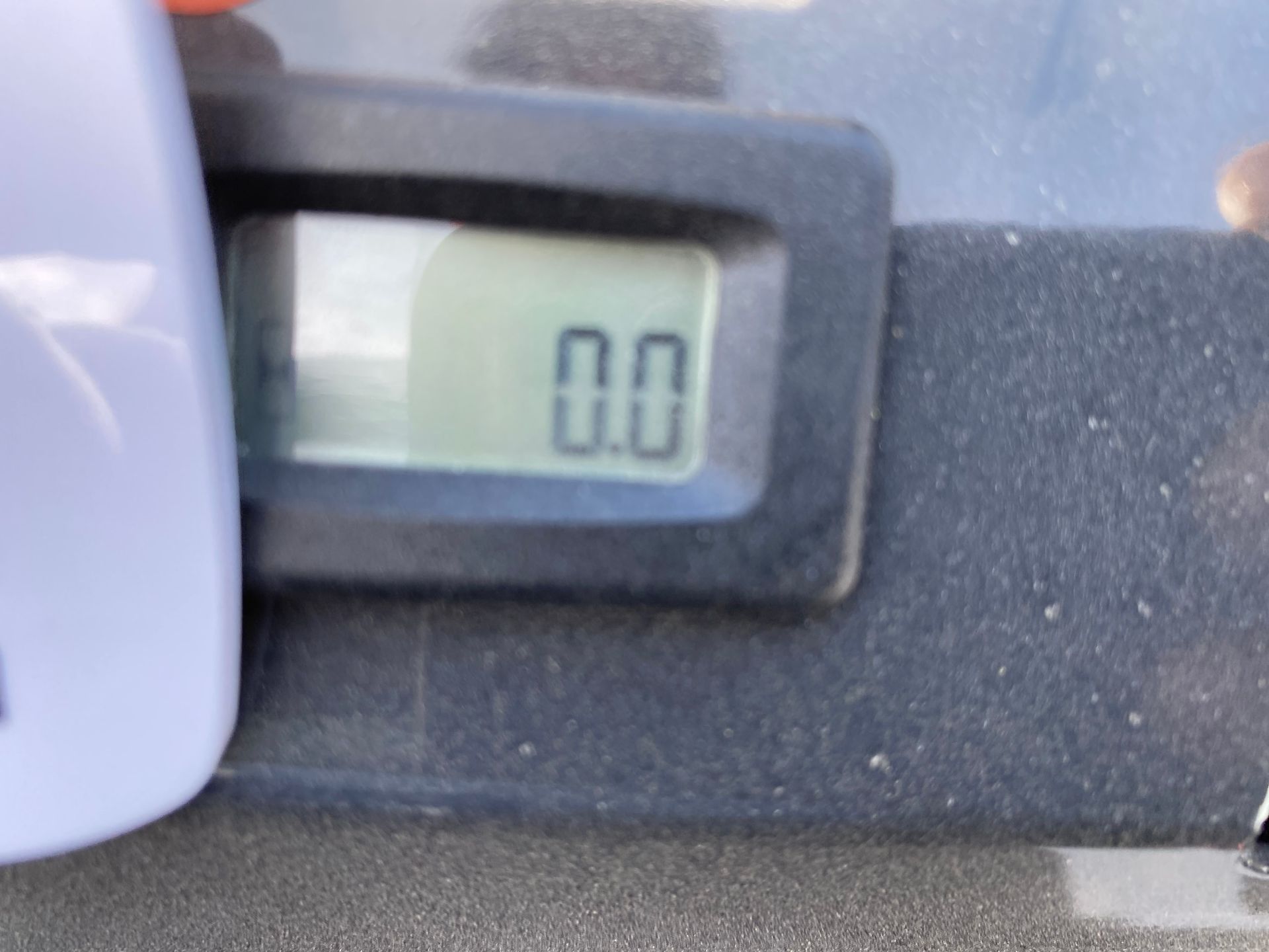 Digital scale displaying 0.0, next to a white object.