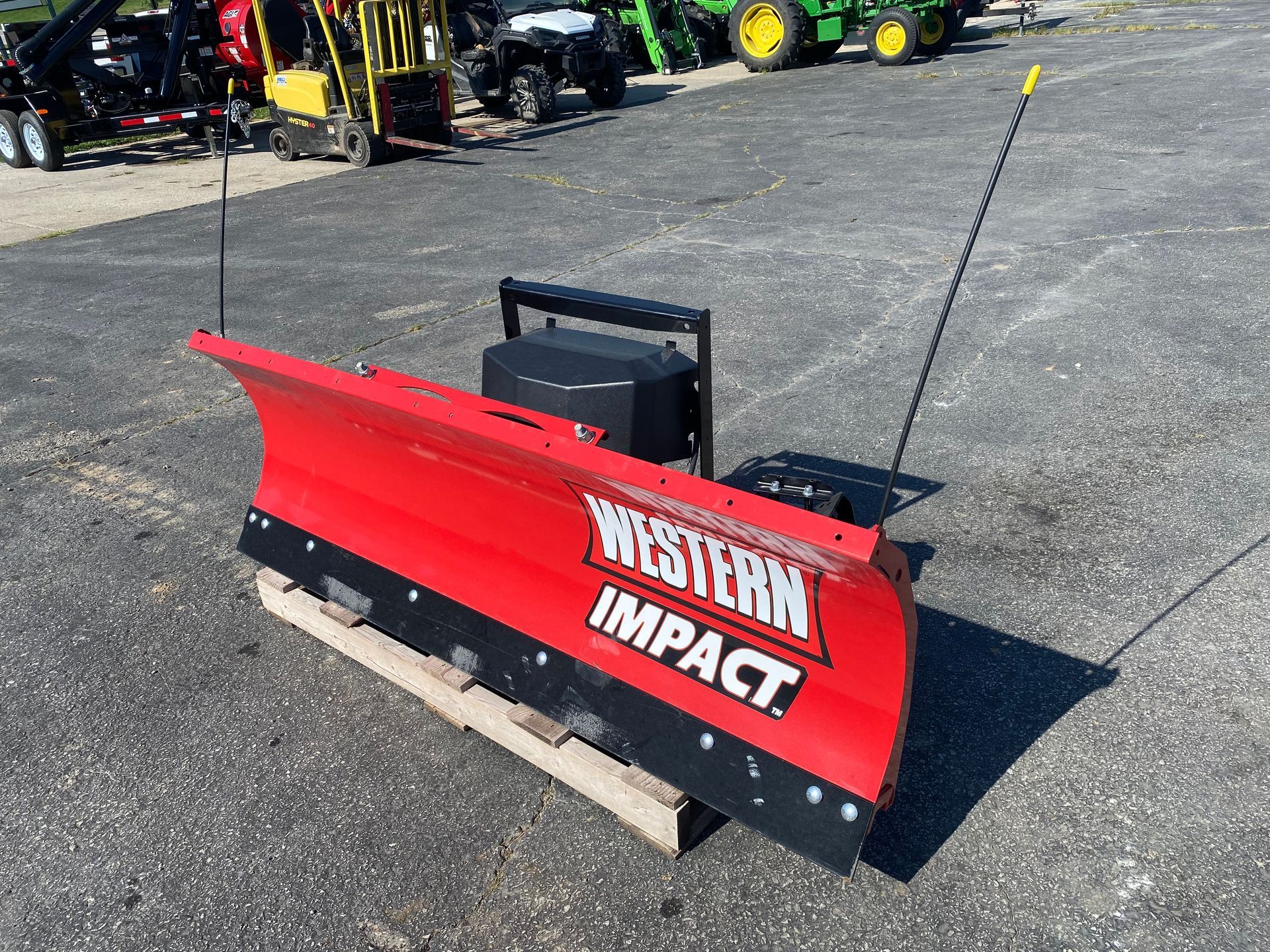 Red Western Impact blade on a pallet, outdoors, with black antennas.
