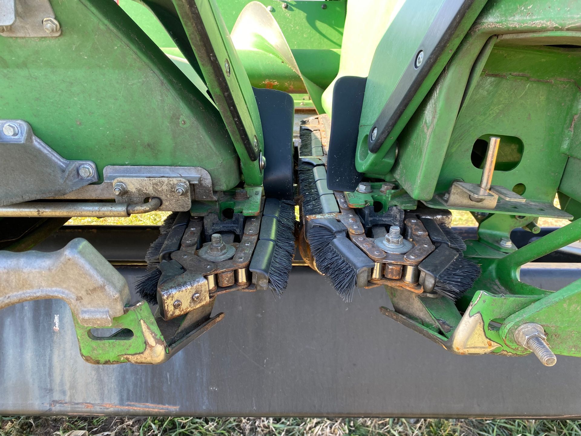 Green and black corn head: two furrow opener blades with seed brushes.