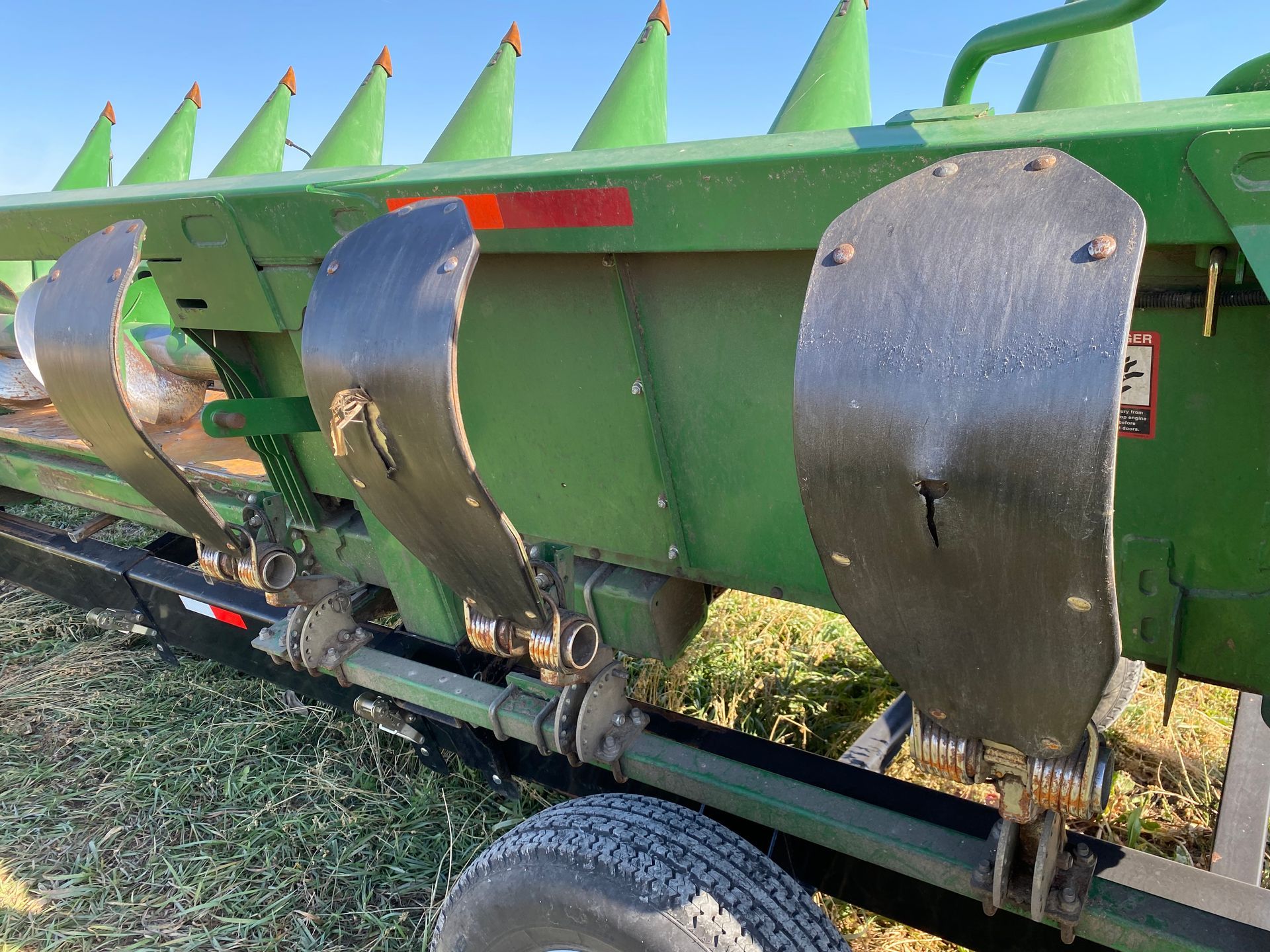 Green corn head attachment; green body, outdoor setting.