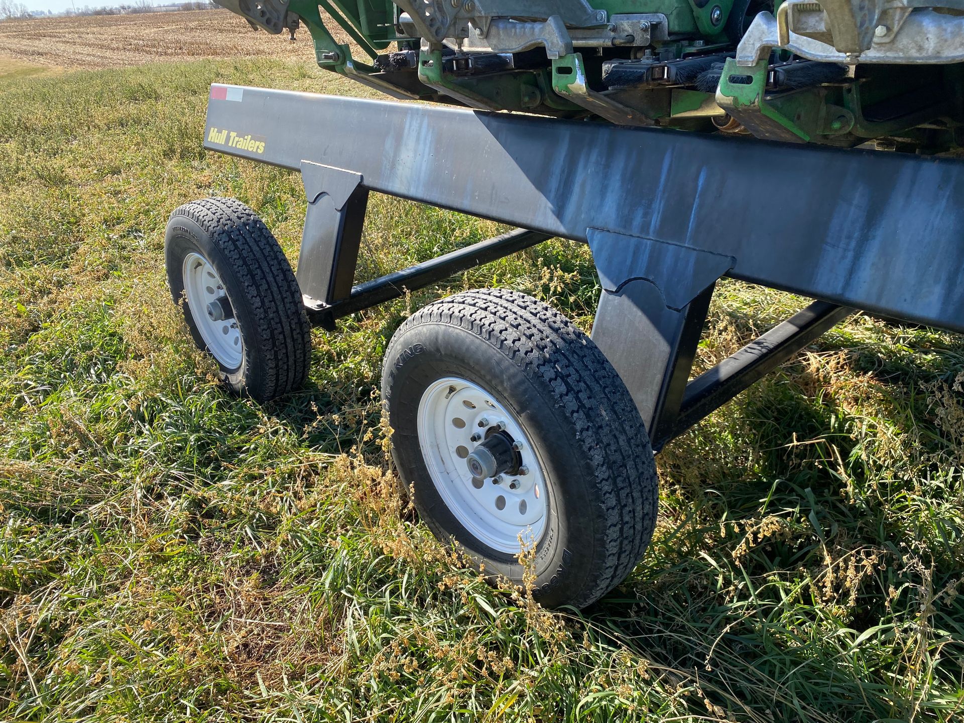 Black wheeled trailer on grassy field.