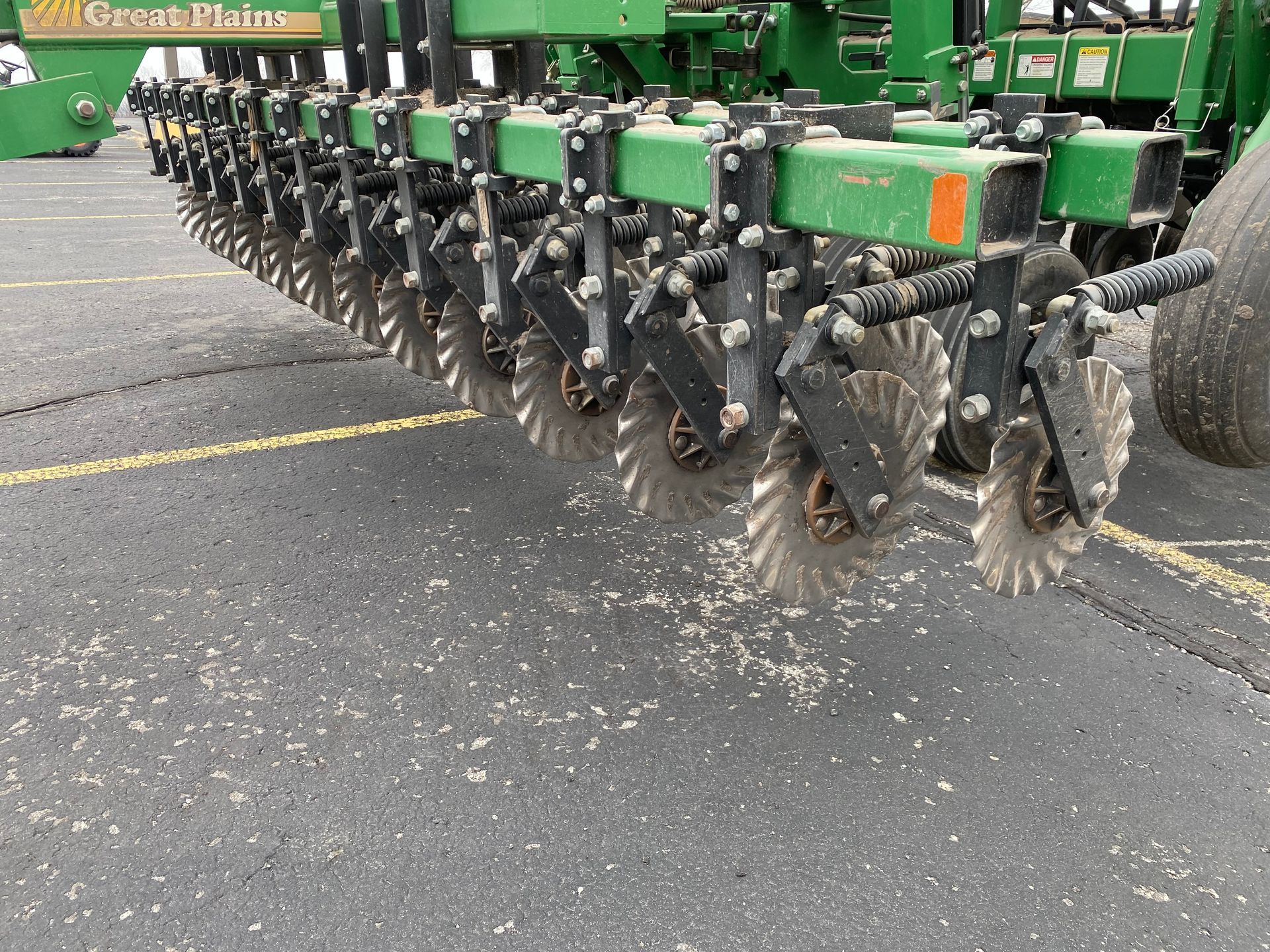 Green farm implement with multiple circular blades.
