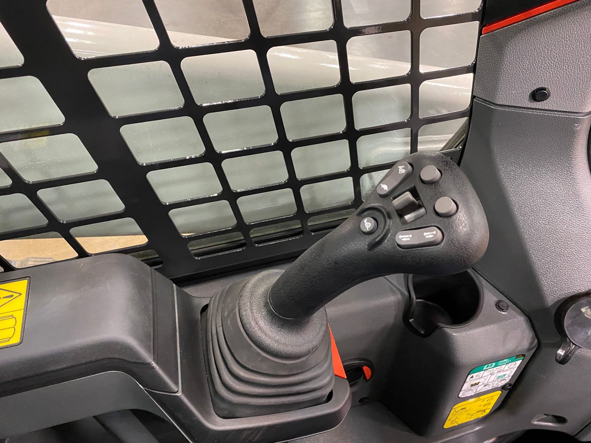 Black control stick with buttons, likely for operating heavy machinery.