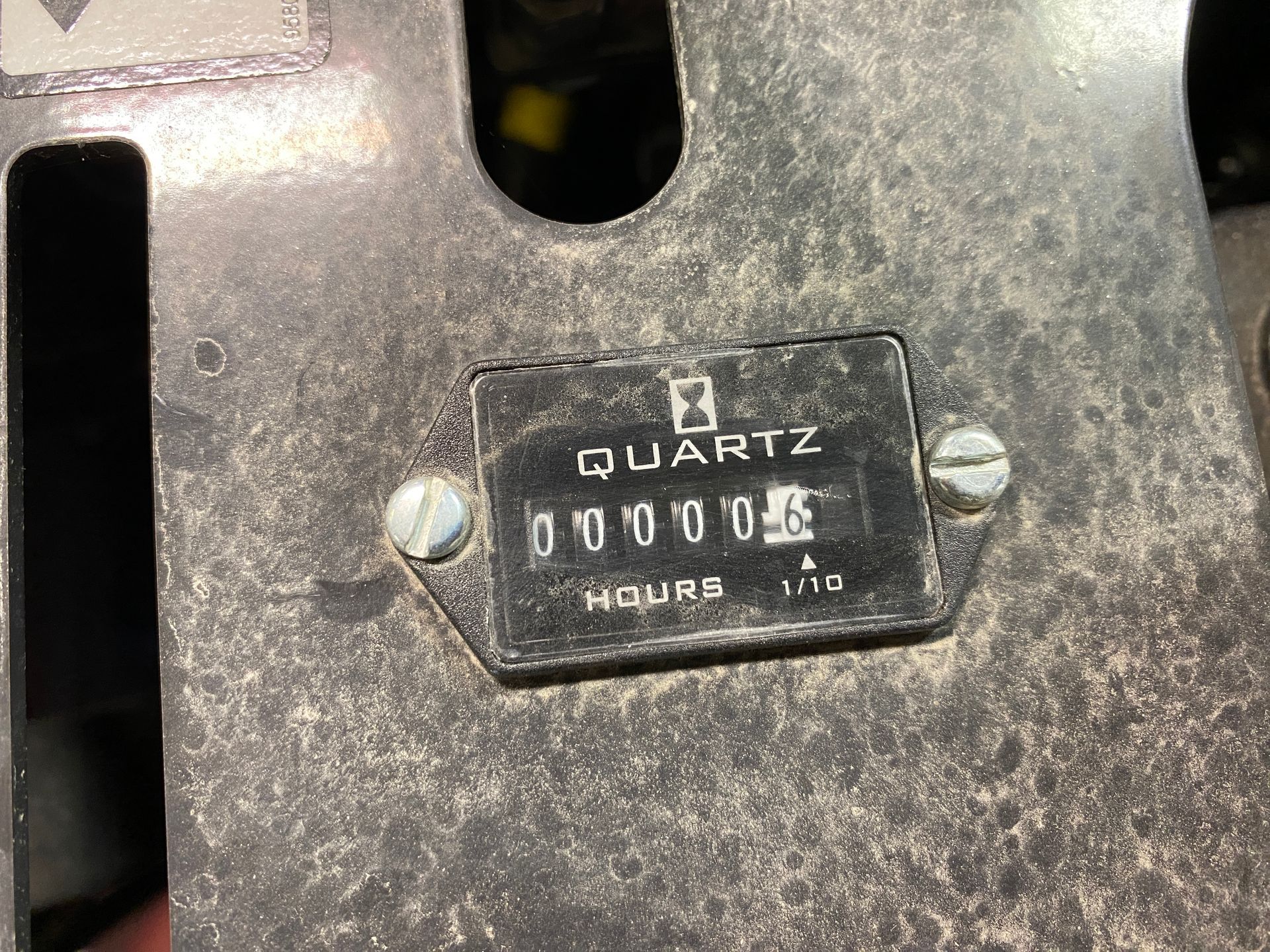 A black quartz hour meter displaying 00004.1 hours, mounted on a dusty metal surface.