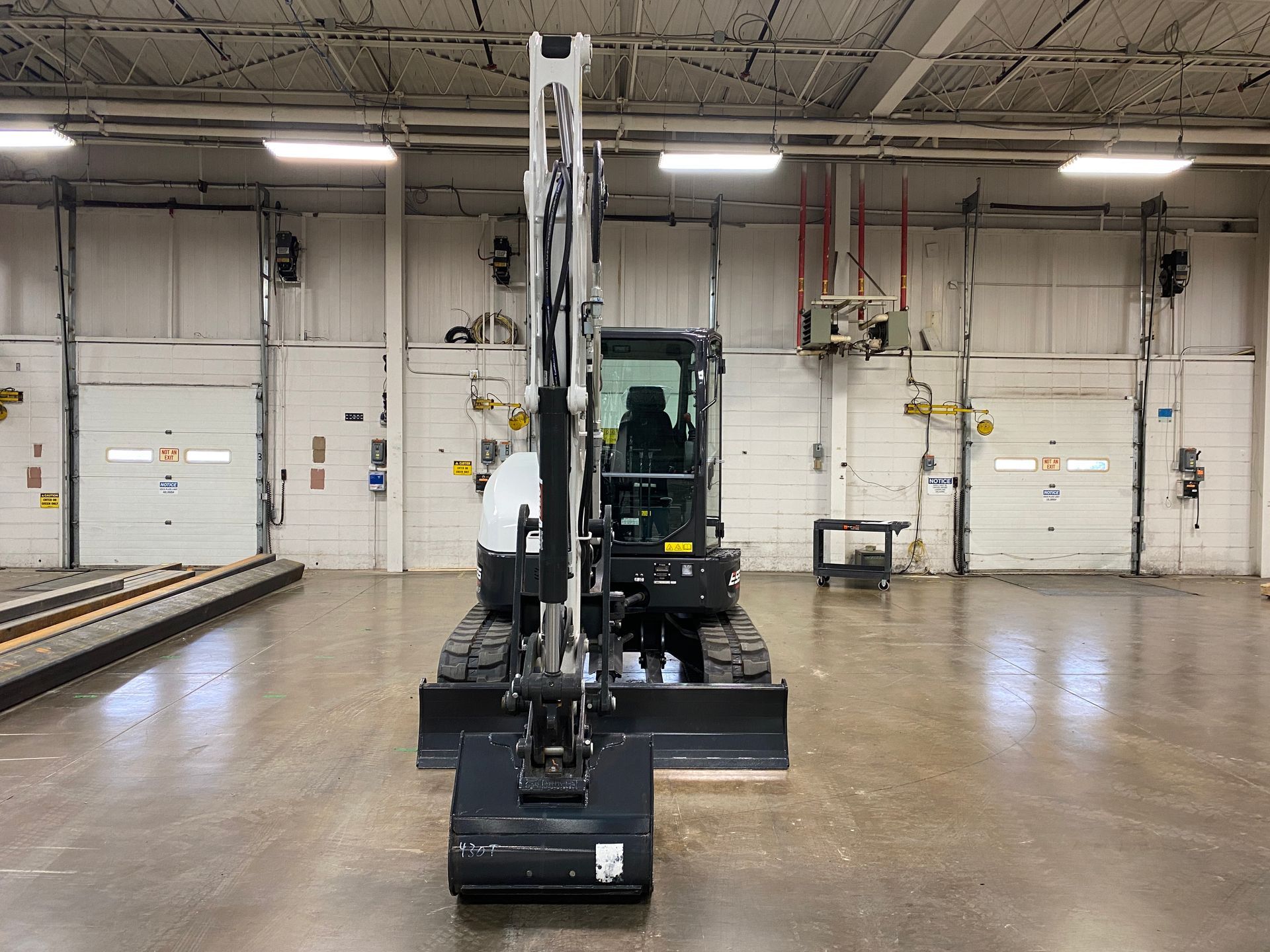 Small excavator with bucket in a garage.