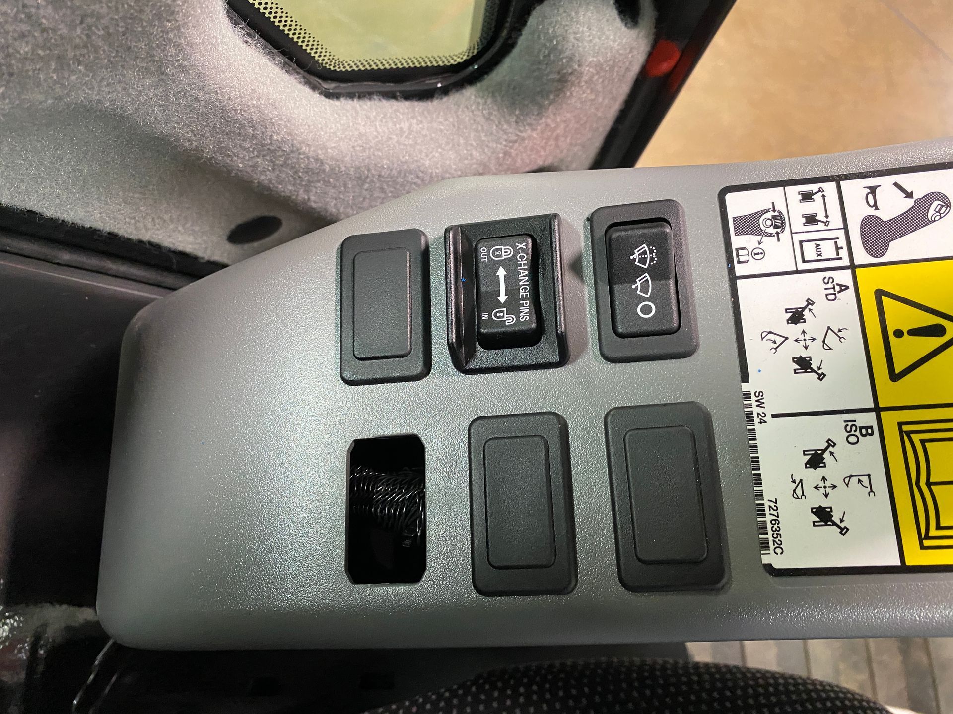 Control panel with five black switches and a vacant slot on gray surface.