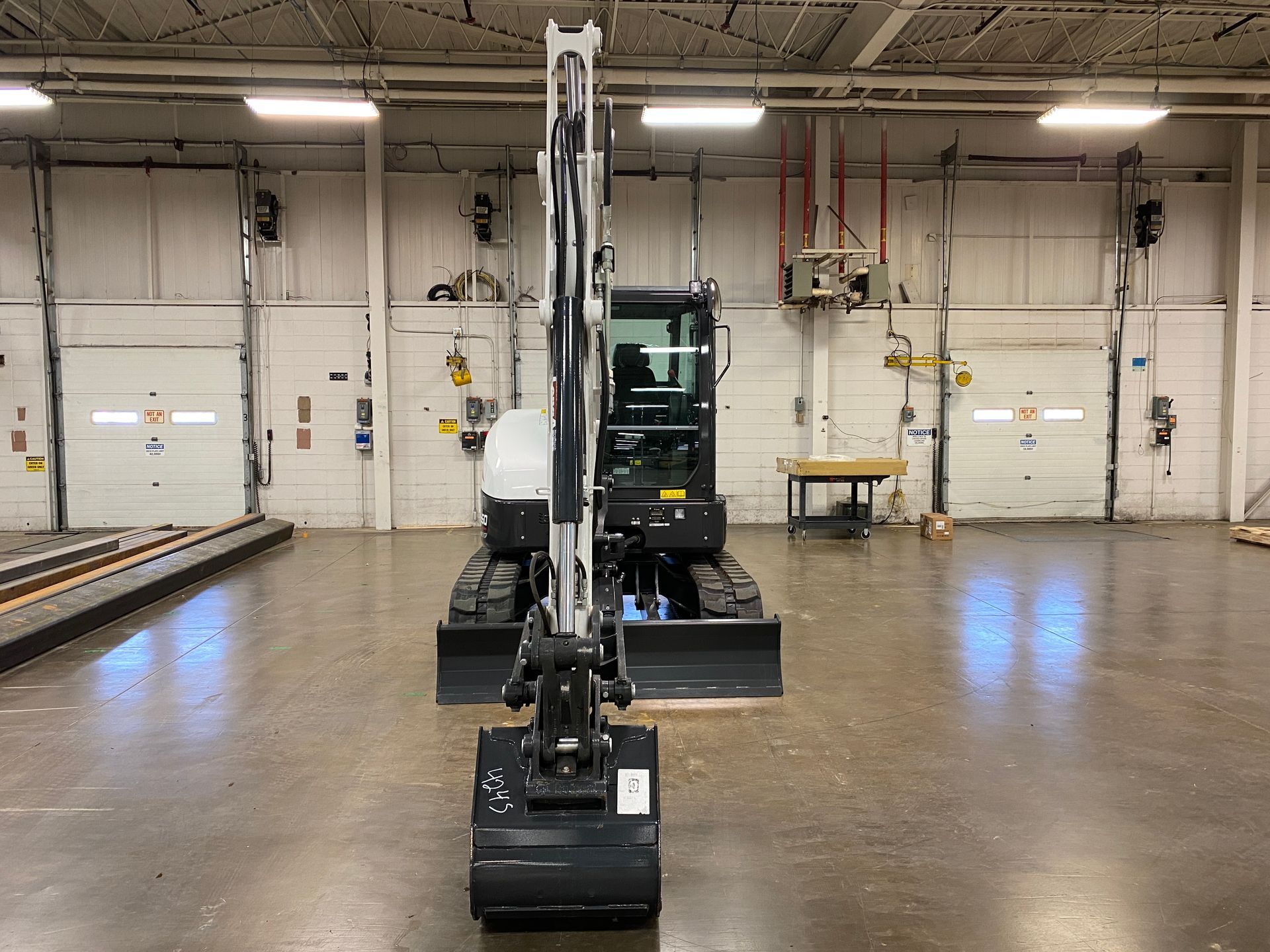 Small excavator in an indoor warehouse setting.