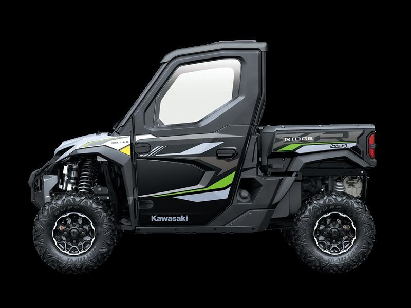 Black and green Kawasaki Mule side-by-side utility vehicle with a cab and truck bed.