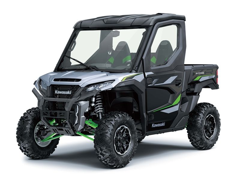 Kawasaki UTV in grey and black with green accents, large tires, and enclosed cab.
