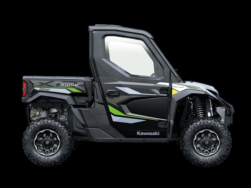 Side view of a black and green Kawasaki Ridge UTV with a cab and bed, on a black background.