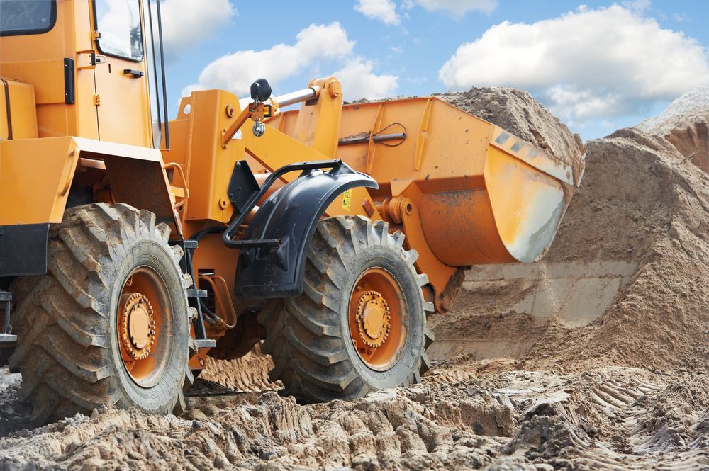 A Yellow Bulldozer is Moving Dirt on a Construction Site — Koumala Quarry In Sarina, QLD
