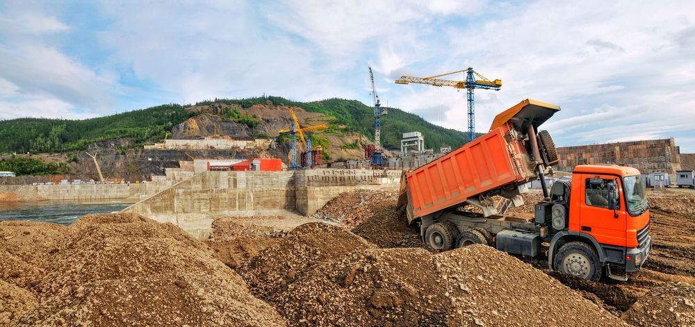 A Dump Truck is Loading Dirt Into a Pile at a Construction Site — Koumala Quarry In Nebo, QLD