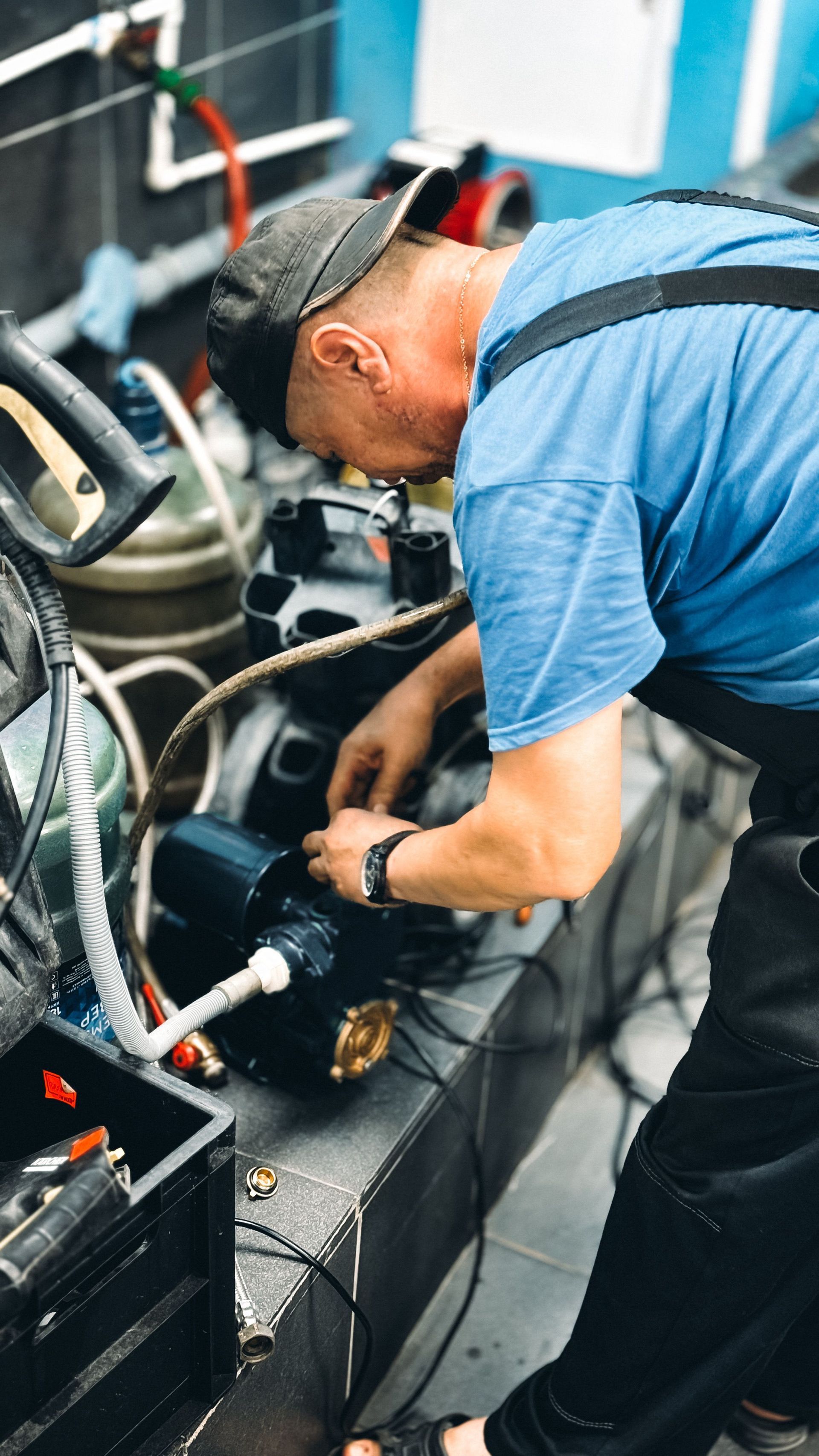 Technician in blue shirt working on cables inside an equipment rack at an outdoor event setup