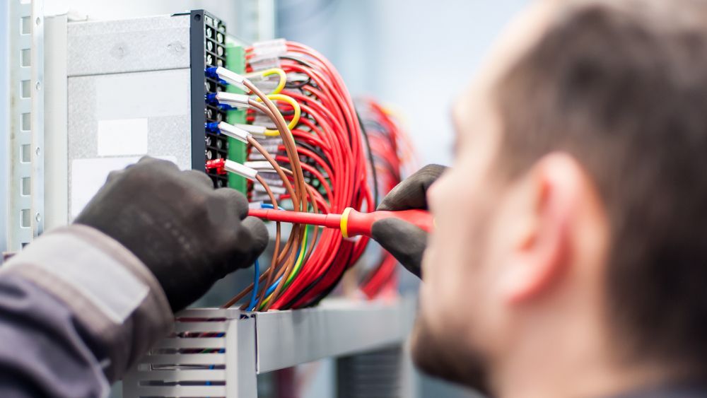 Electrician Connecting Wires With a Screwdriver — KAC Generation & Mechanical Pty Ltd In Bungalow, QLD